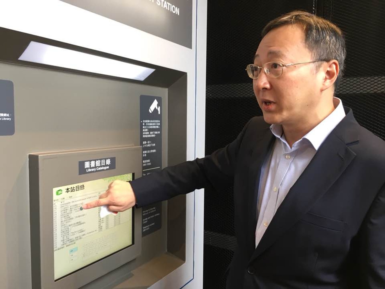 李子俊介紹,自助圖書站設有三部機器,分別為資料介紹、借還操作及使用介紹。(李慧妍攝) 李子俊介紹,自助圖書站設有三部機器,分別為資料介紹、借還操作及使用介紹。(李慧妍攝)