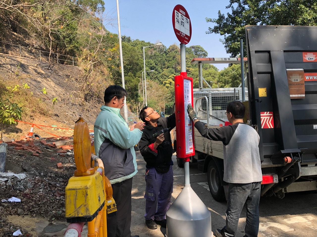 有九巴職員帶同新的站牌，到現場重新設置巴士站。（黃雅盈攝）