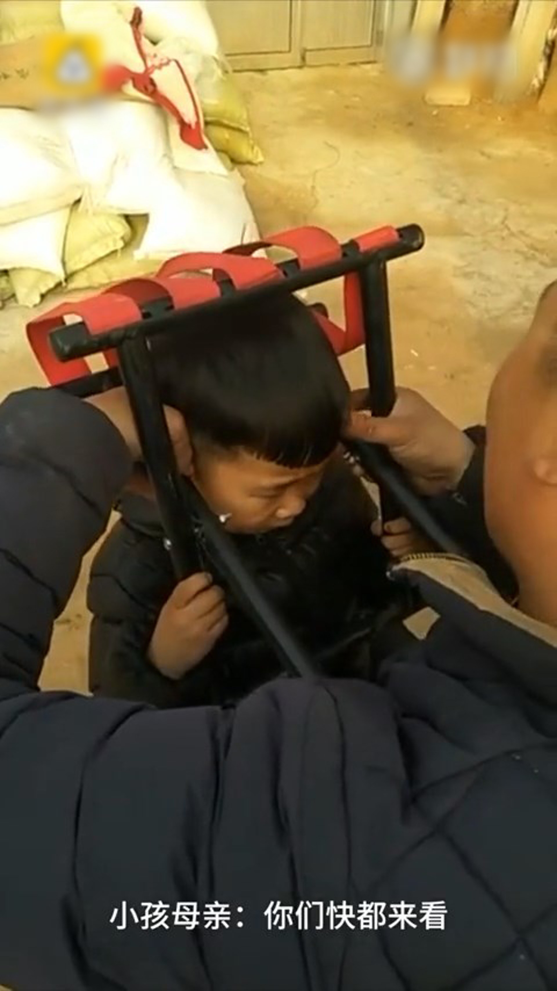 男童的頭部被卡在摺櫈中無法脫困,其媽媽在場拍片大笑,還叫人齊齊觀看兒子的洋相,直到小孩哭求「別錄了」才停止。(梨視頻片段截圖) 男童的頭部被卡在摺櫈中無法脫困,其媽媽在場拍片大笑,還叫人齊齊觀看兒子的洋相,直到小孩哭求「別錄了」才停止。(梨視頻片段截圖)