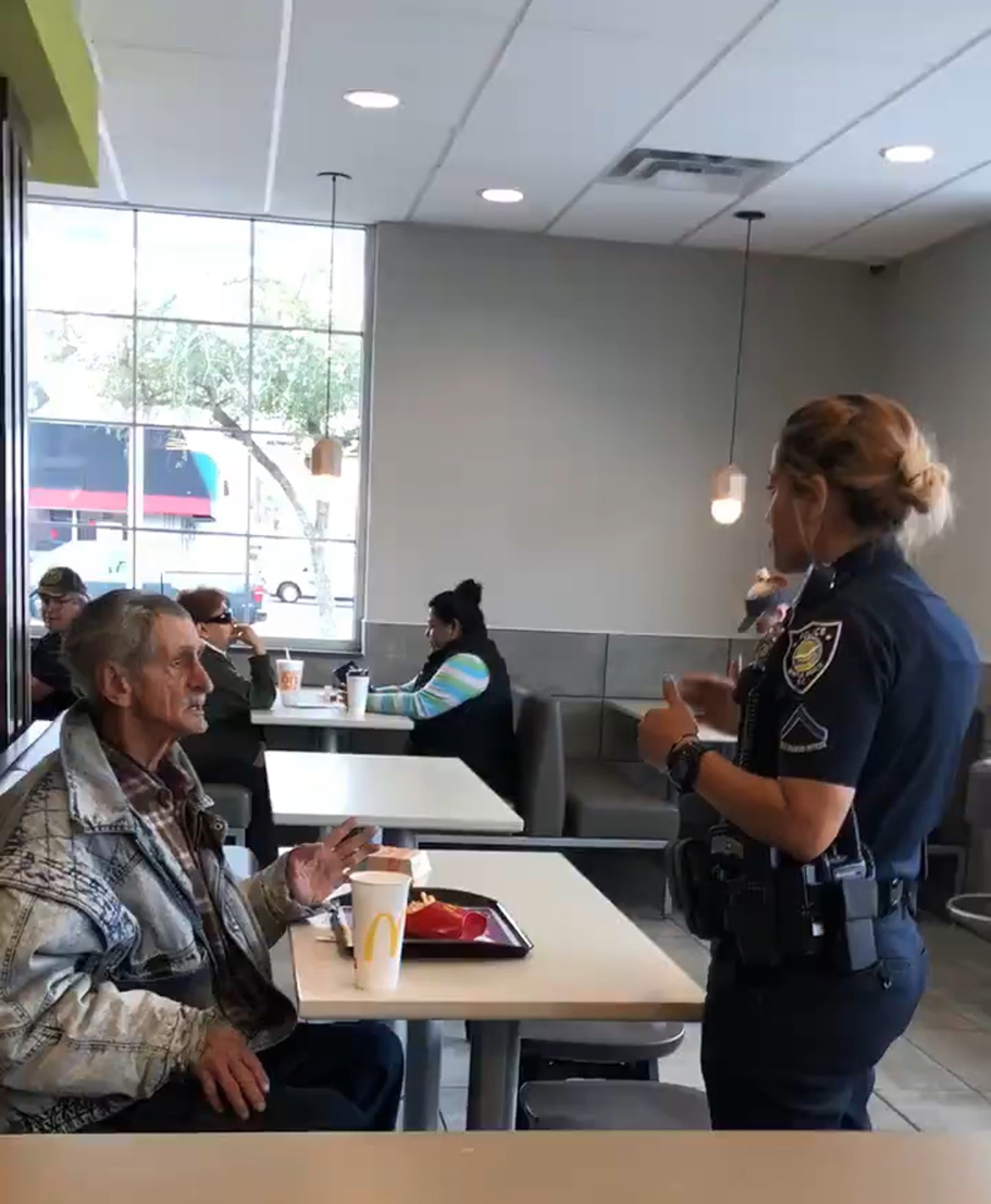 露宿者在麥當勞用餐時,餐廳報警求助,一名女警到場要求露宿者離開。(Yossi Gallo fb片段截圖) 露宿者在麥當勞用餐時,餐廳報警求助,一名女警到場要求露宿者離開。(Yossi Gallo fb片段截圖)