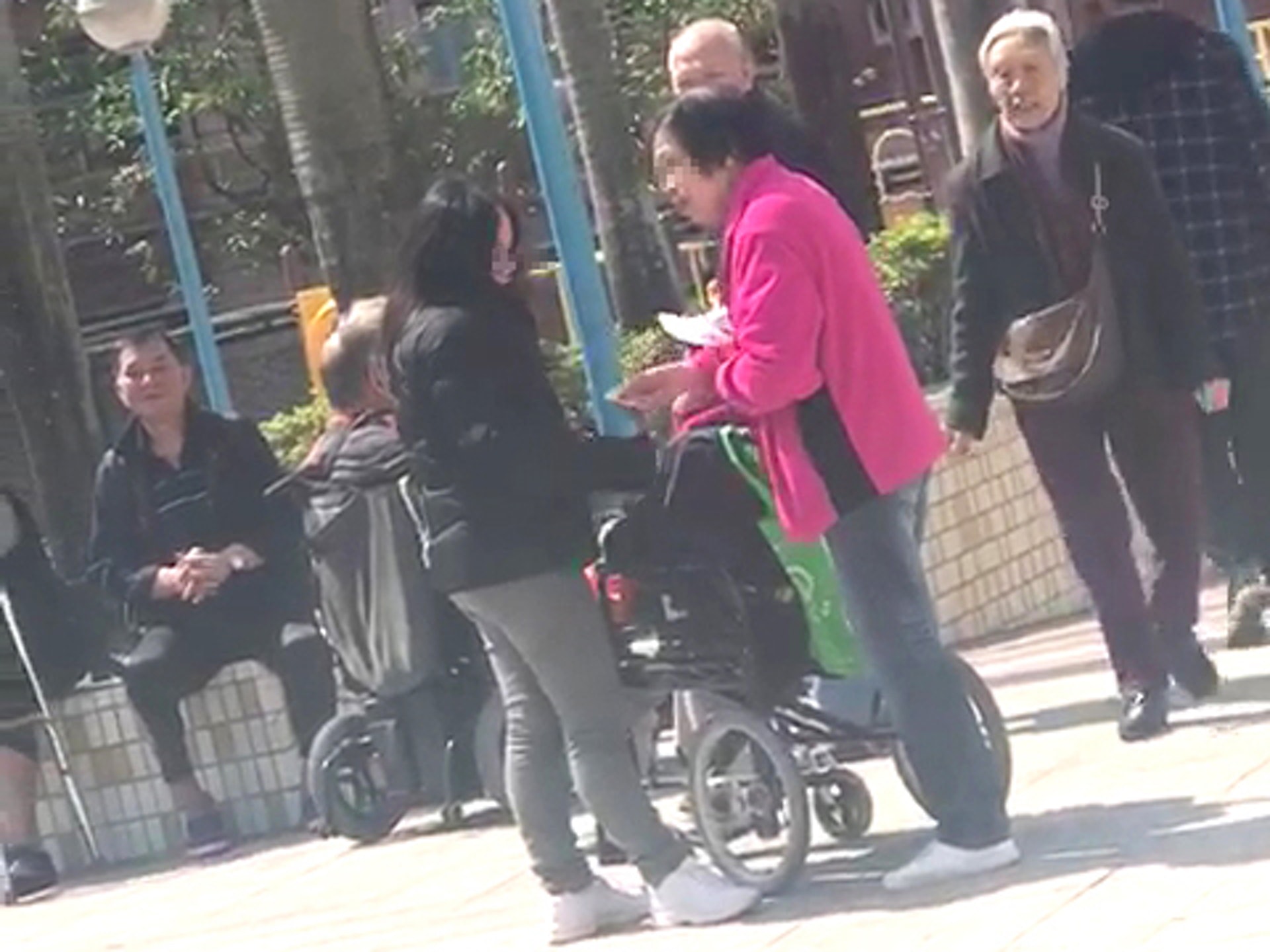 社總義工發現,土瓜灣體育館票站外,一名身穿黑色衫的女士,懷疑向投完票的長者收集身份證。(社總義工提供) 社總義工發現,土瓜灣體育館票站外,一名身穿黑色衫的女士,懷疑向投完票的長者收集身份證。(社總義工提供)