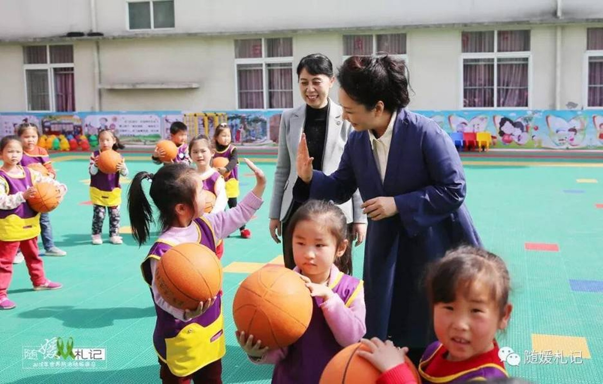 在當地小學,彭麗媛和孩子們一起做遊戲。(網上圖片) 在當地小學,彭麗媛和孩子們一起做遊戲。(網上圖片)