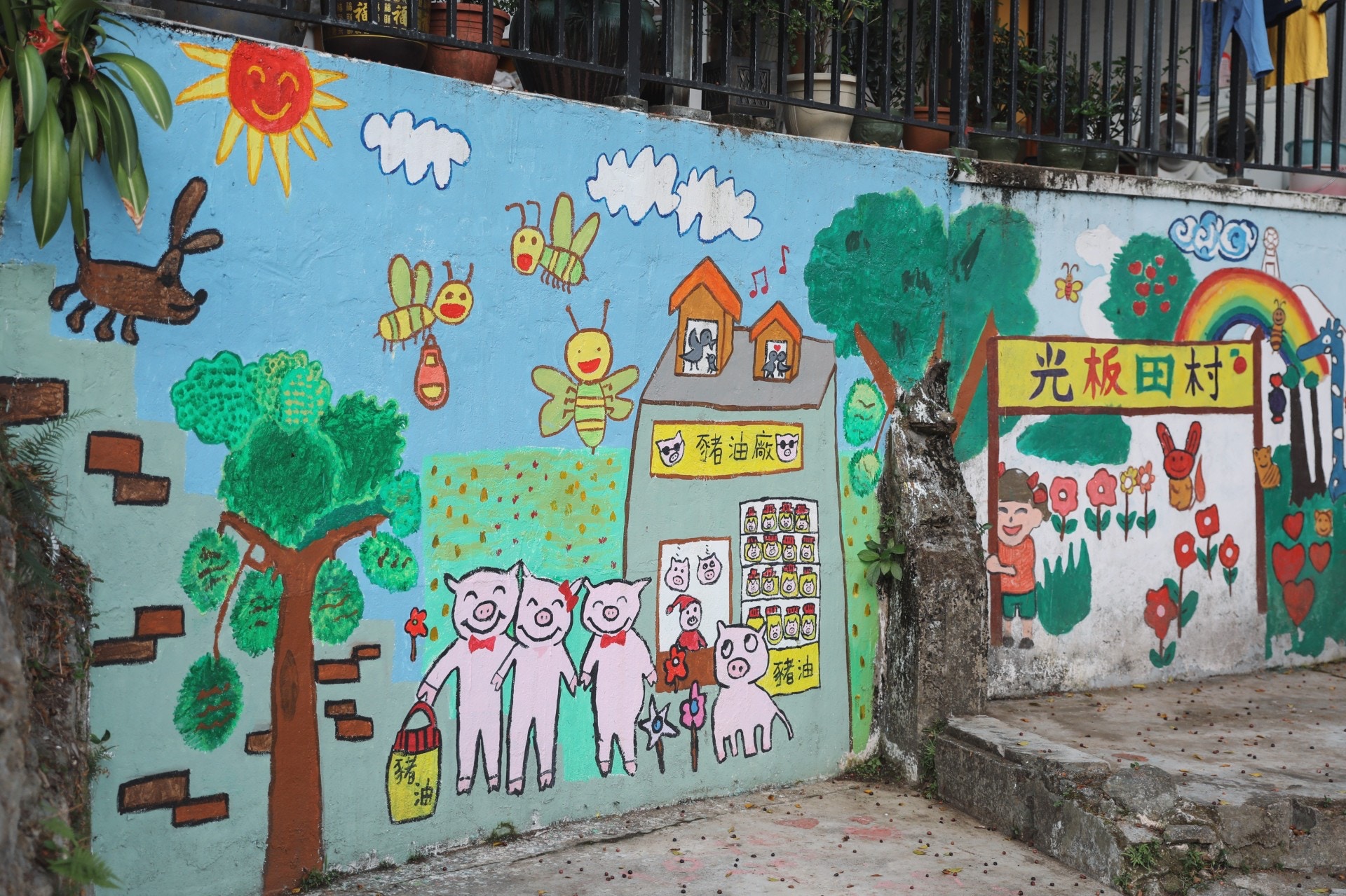 光板田村到處也能看到七彩的壁畫，畫有村內常見的動物，好如松鼠、養蜂場內的蜜蜂、小豬們以及常見的貓狗。畫中的村民與動物均笑臉迎人，看似相處融洽，然而在現實中，村子虐畜事件頻生，令畫作頓顯諷刺。(沈敏怡攝)