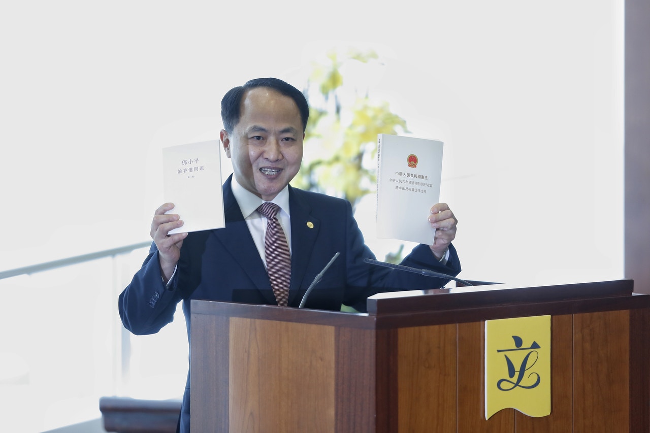 王志民向立法會送兩本書，一本為憲法與基本法合訂本，另一本為《鄧小平論香港問題》。（張浩維攝）