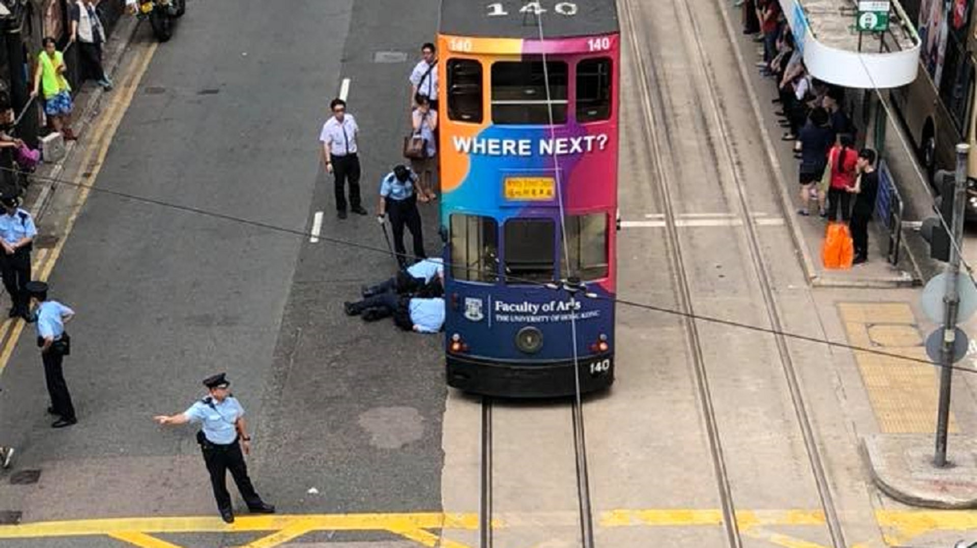 兩名警員伏在地上試圖救貓。（FaceBook《香港突發事故報料區》）