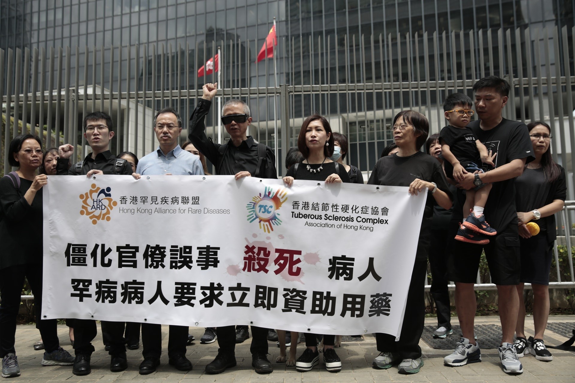 病人組織與立法會議員張超雄去年在池燕蘭離世後,到政府總部外抗議。前排右一持橫額者是江太。(林若勤攝/資料圖片) 病人組織與立法會議員張超雄去年在池燕蘭離世後,到政府總部外抗議。前排右一持橫額者是江太。(林若勤攝/資料圖片)