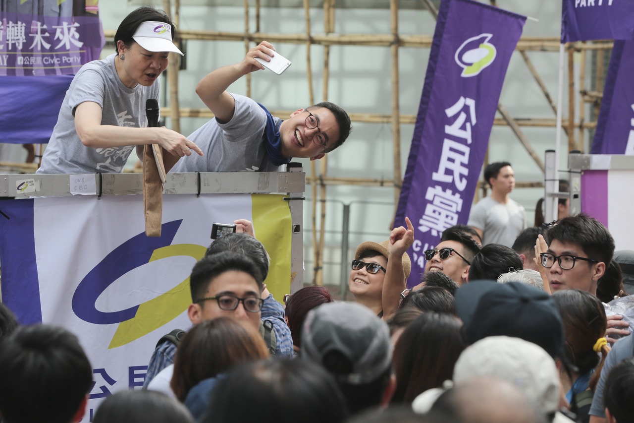 余若薇和楊岳橋昨日一同站台宣傳，楊岳橋不忘與遊行人士自拍。(羅君豪攝)
