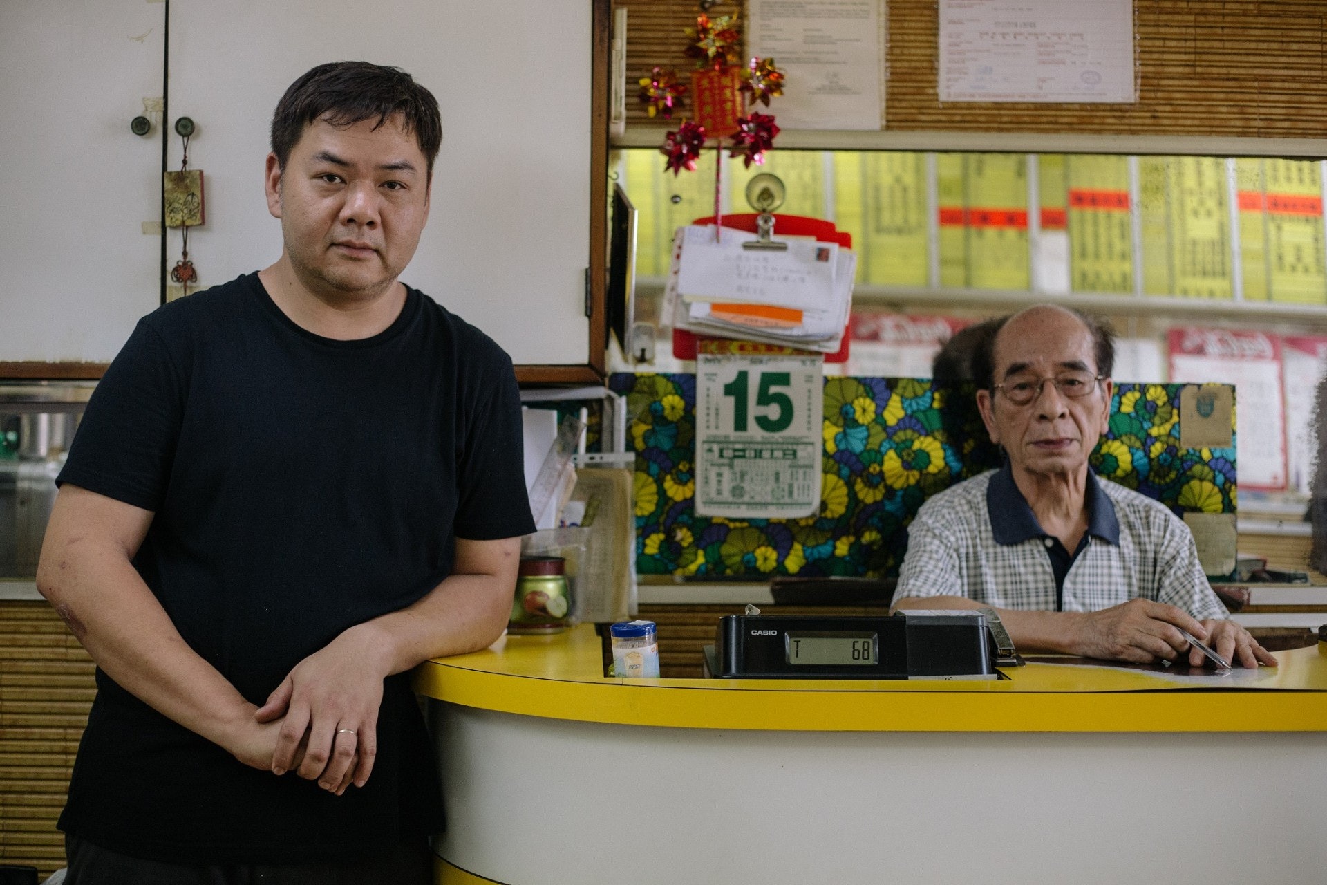 父親(右)一手做起「發發快餐」,兒子關先生(左)自小在餐廳長大,考試前夕甚至在店內溫習,餐廳見證著他的成長。(梁鵬威攝) 父親(右)一手做起「發發快餐」,兒子關先生(左)自小在餐廳長大,考試前夕甚至在店內溫習,餐廳見證著他的成長。(梁鵬威攝)