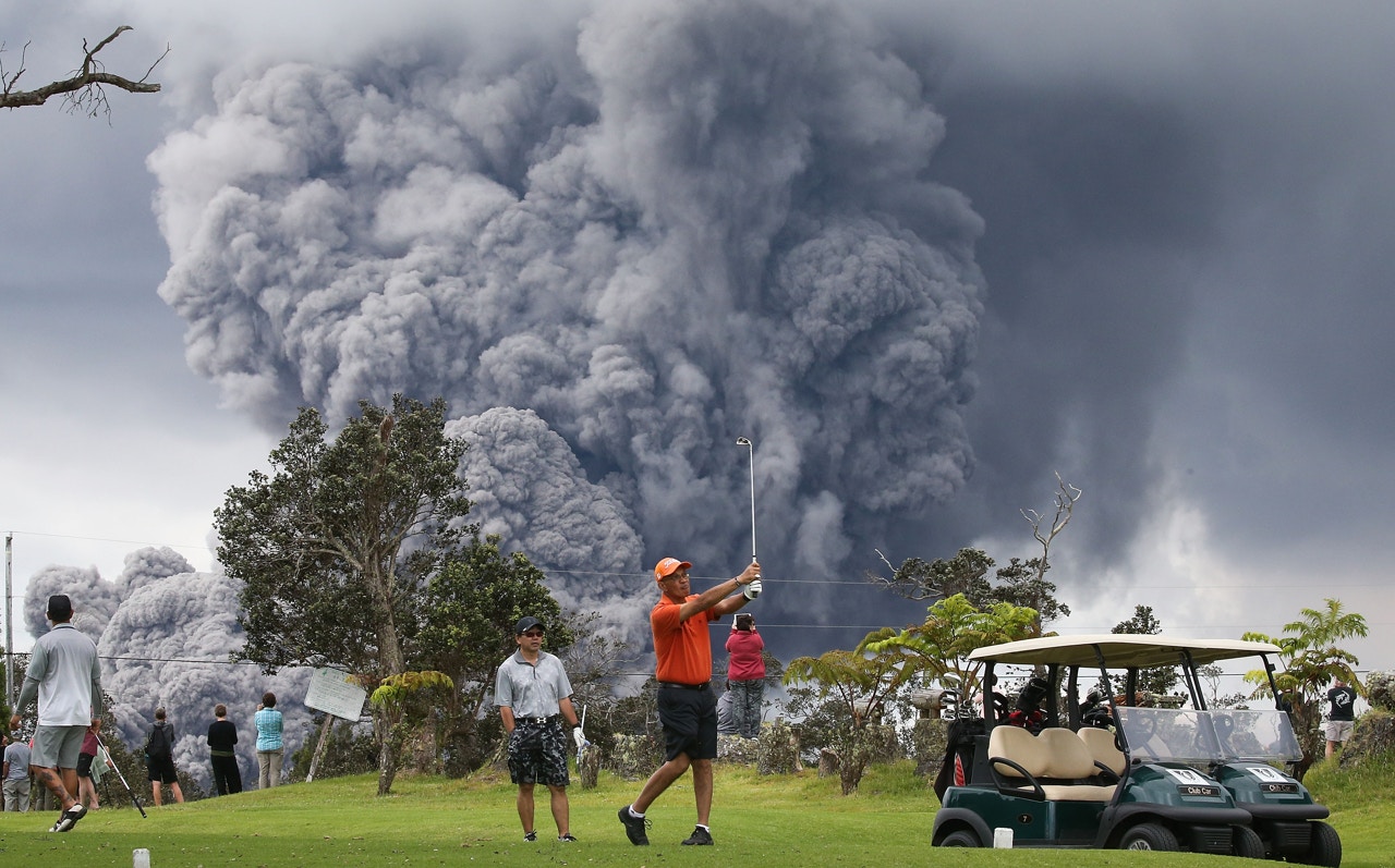5月15日，夏威夷島火山國家公園，濃煙從基拉韋亞火山冒起，人們如常打高爾夫球。（Mario Tama/Getty Images）