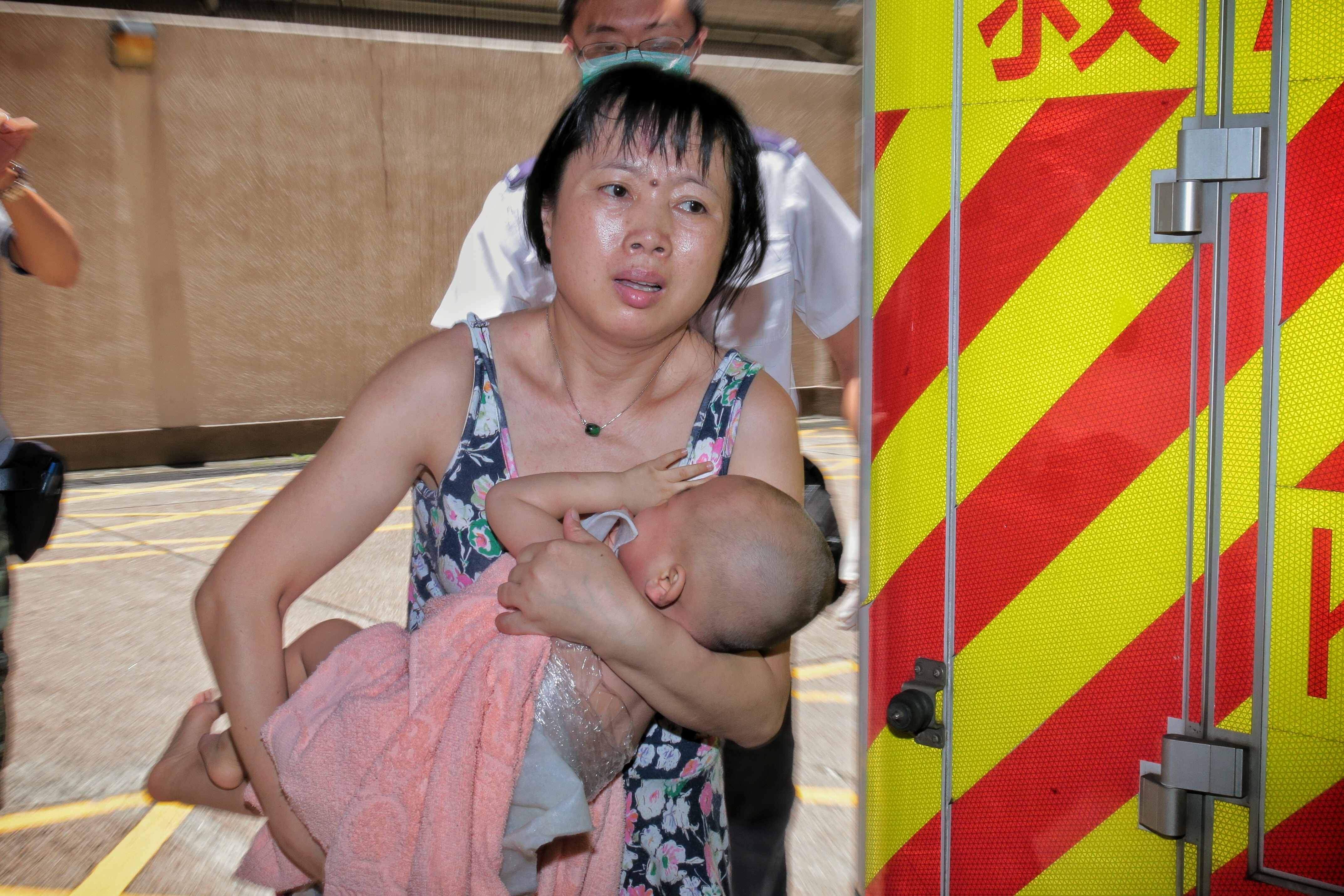 男嬰被送到醫院治理，其母神情緊張。 （梁銘康攝）