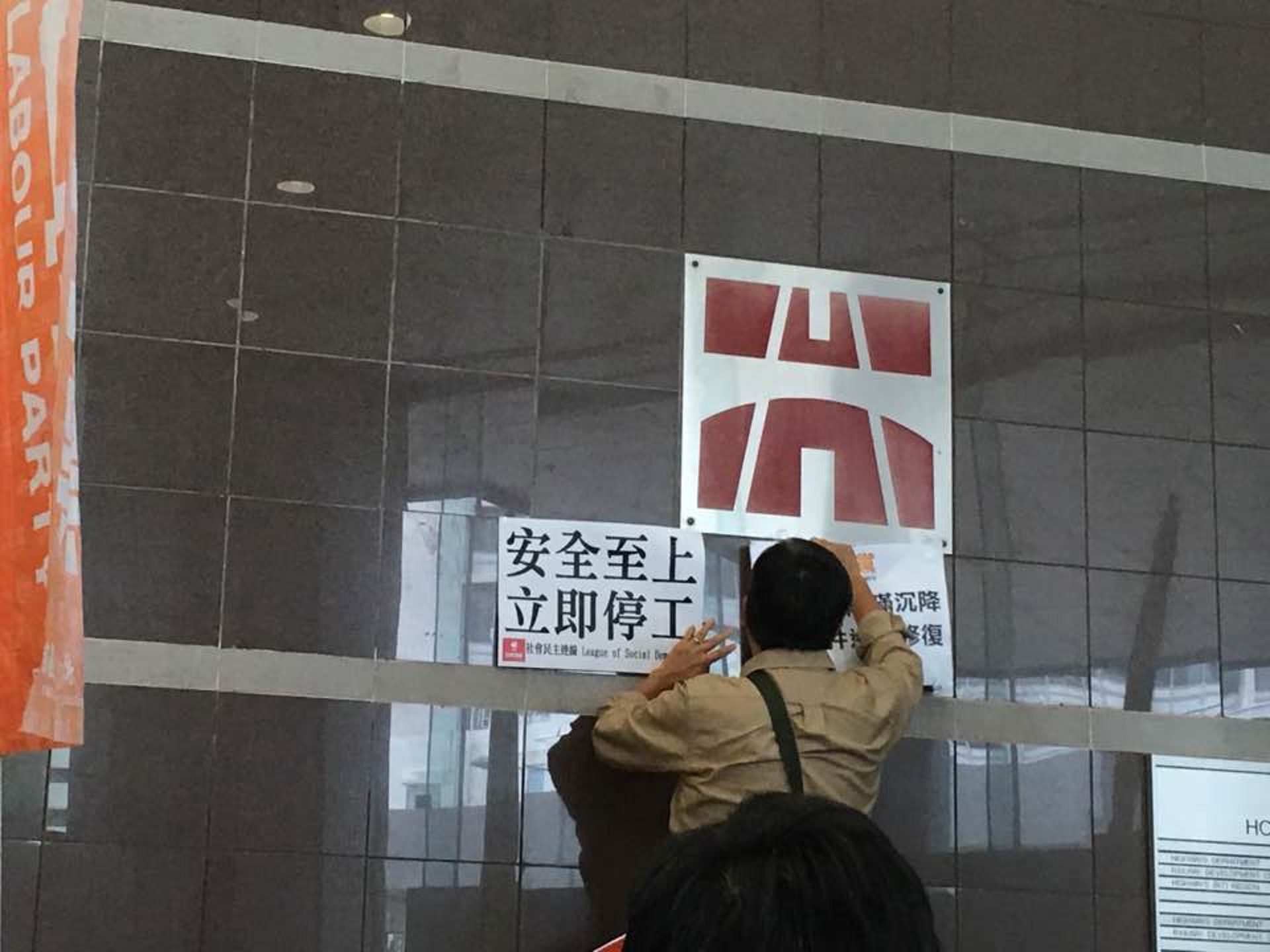 多名民主派立法會議員及地區人士今午到路政署抗議,要求署方勒令港鐵就土瓜灣站停工。 圖為示威者將標語貼在路政署標誌下。(李偉欣攝) 多名民主派立法會議員及地區人士今午到路政署抗議,要求署方勒令港鐵就土瓜灣站停工。 圖為示威者將標語貼在路政署標誌下。(李偉欣攝)