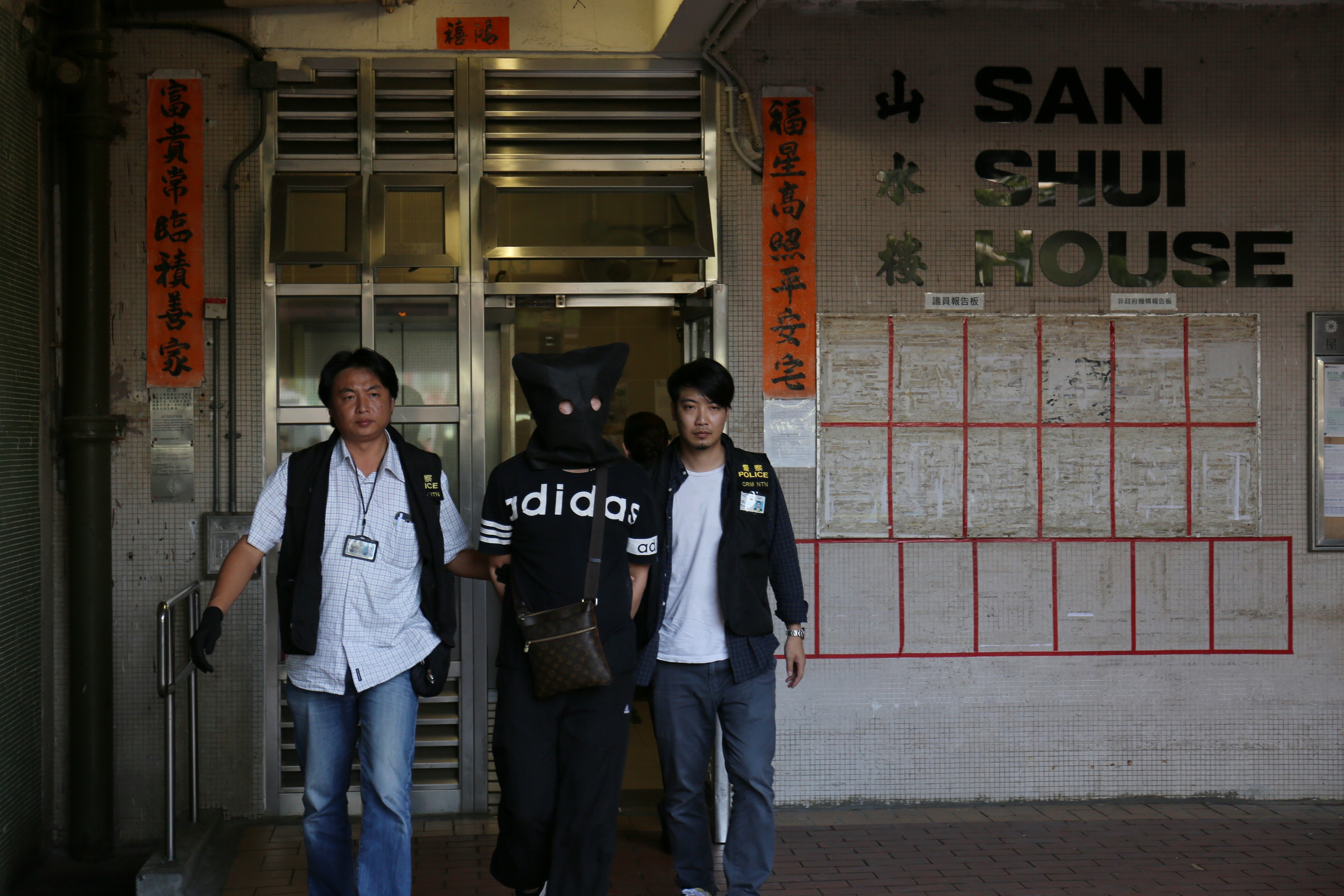 39歲姓干男子下午被警員押返水邊圍邨山水樓寓所搜查。（魯嘉裕攝）