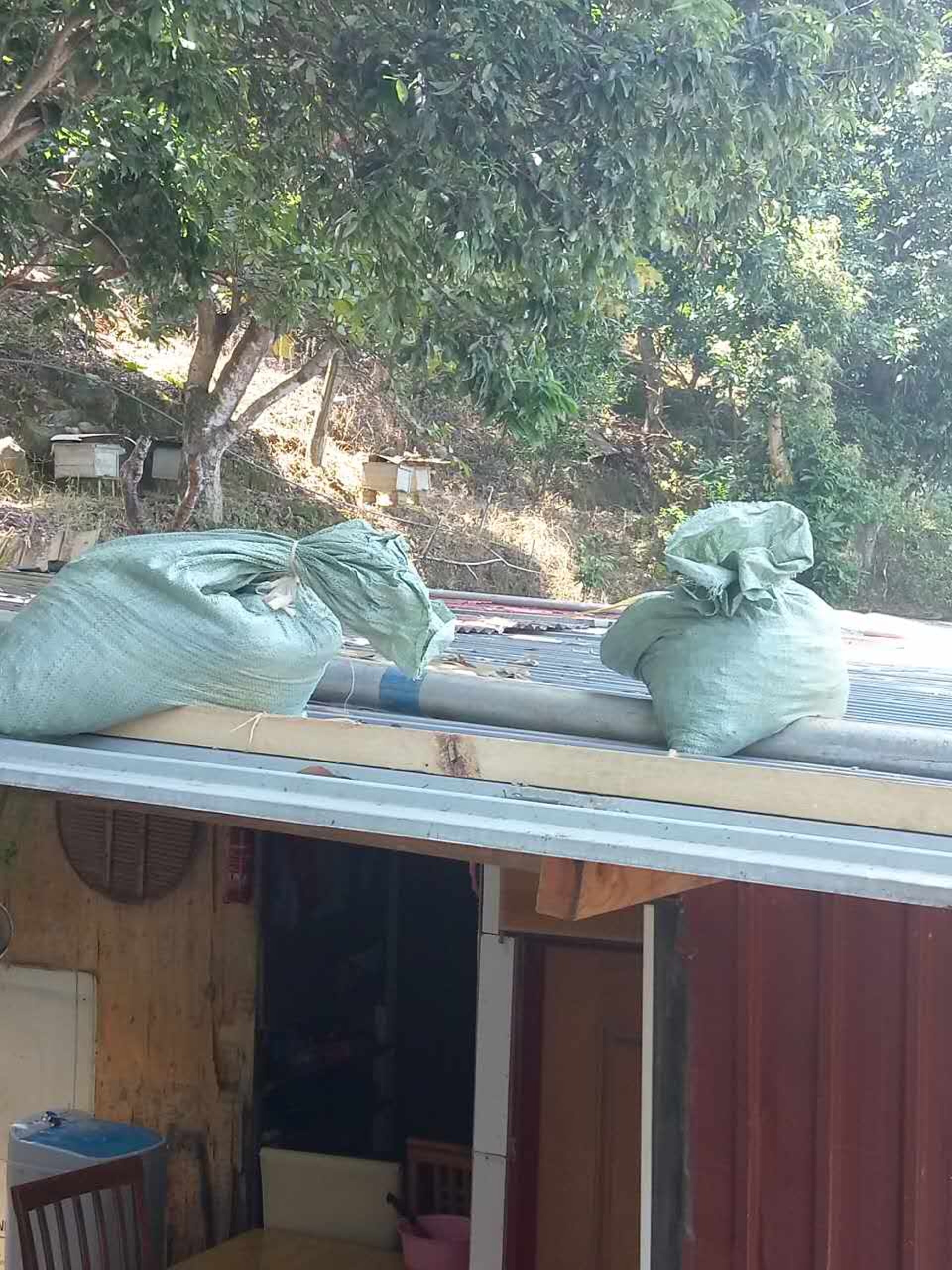 颱風來襲前夕，美虹和萬豪父母在寮屋頂加上沙包，以防被颱風吹塌。