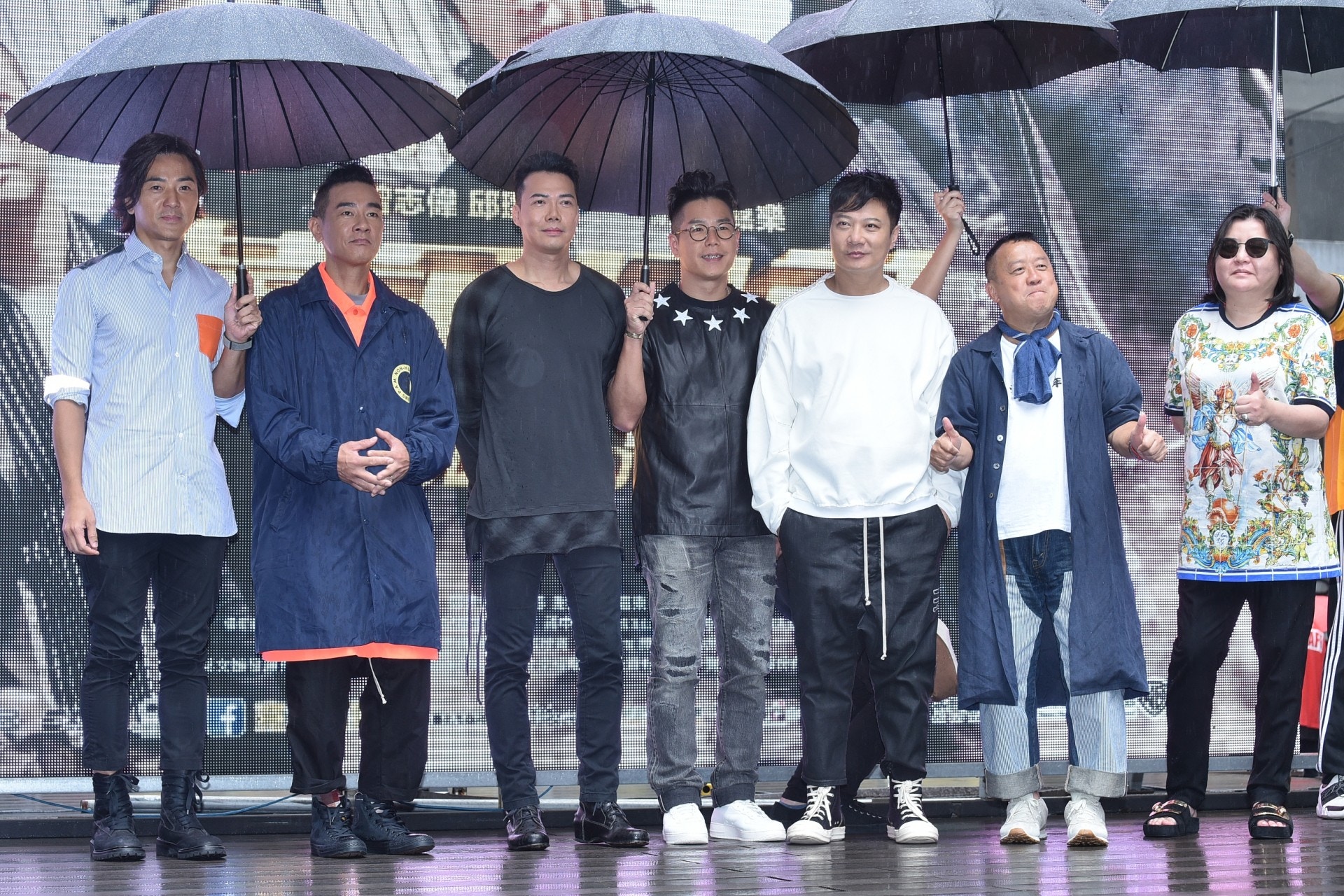 受颱風山竹影響，台北下起雨來，一眾演員出席見面會時要開遮。（視覺中國）