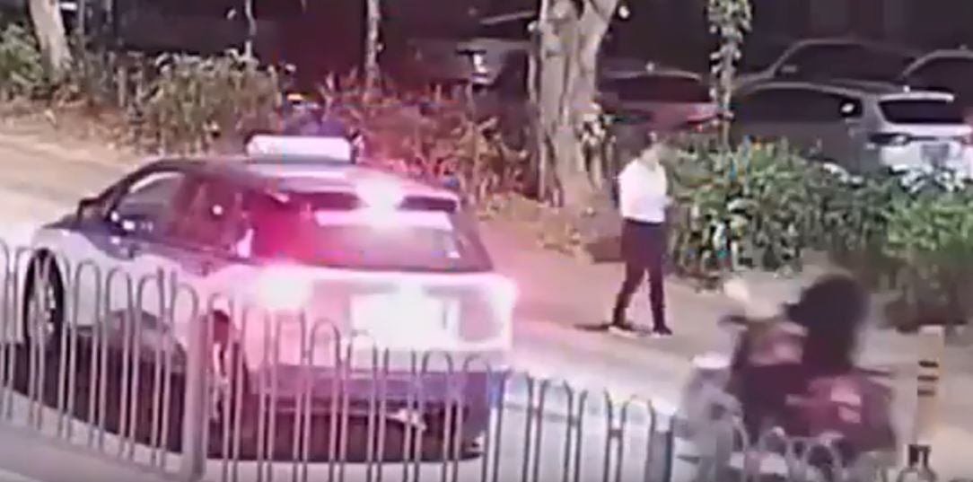 事發時的士停在路邊，摩托車準備從右方駛過。（影片截圖）