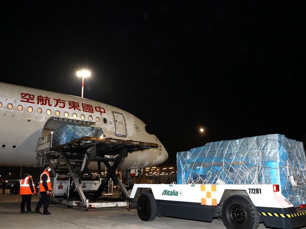 3月12日,在羅馬的機場,工人們從一架中國包機上卸下醫療用品。當天,一架載有醫療小組成員和幾噸來自中國的醫療物資的包機抵達羅馬,幫助意大利抗擊冠狀病毒疫情。(AP) 3月12日,在羅馬的機場,工人們從一架中國包機上卸下醫療用品。當天,一架載有醫療小組成員和幾噸來自中國的醫療物資的包機抵達羅馬,幫助意大利抗擊冠狀病毒疫情。(AP)