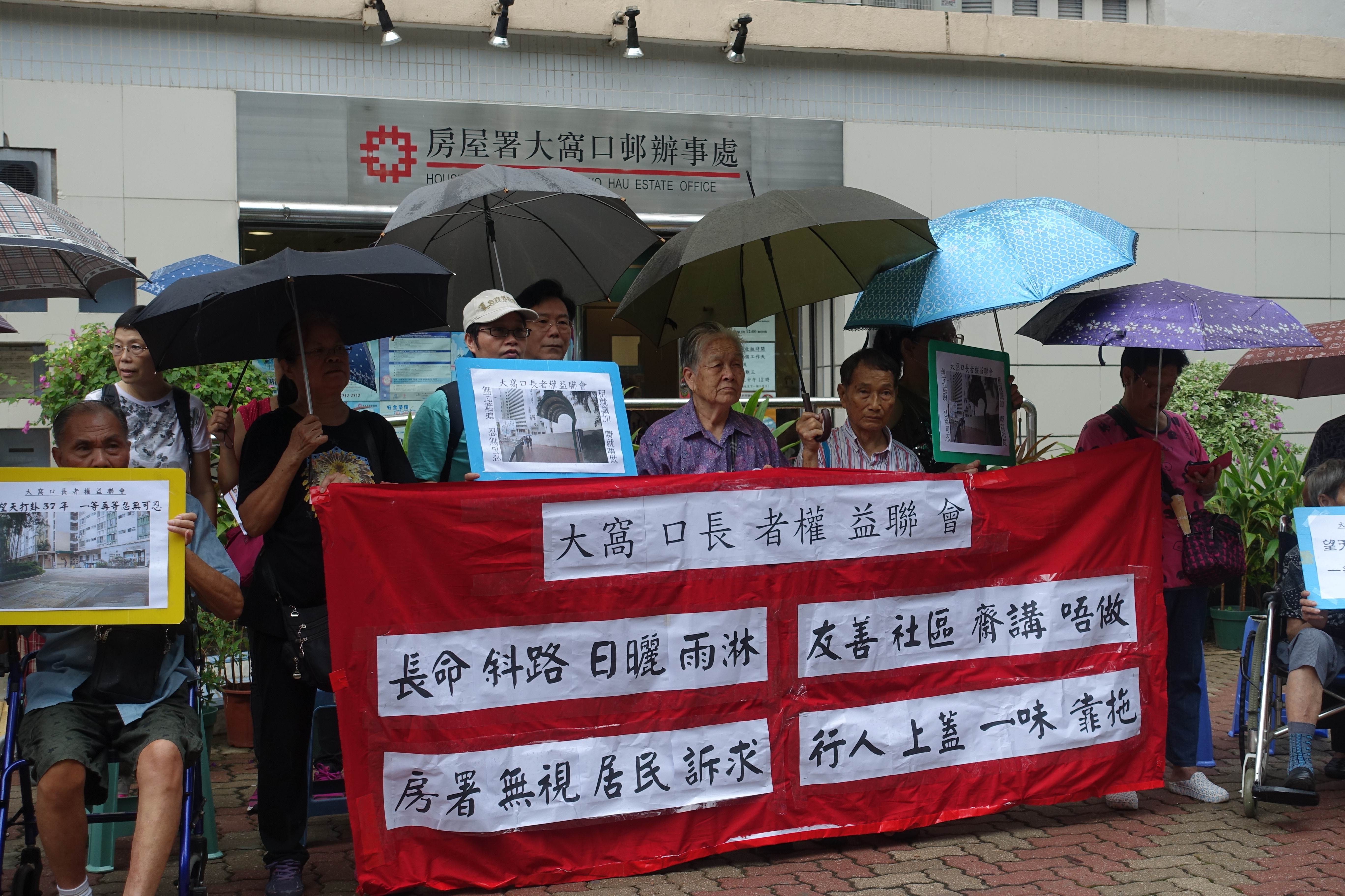 30名公公婆婆冒雨到房署辦事處抗議，要求找數落實興建行人（路）上蓋。（陳銘智攝）