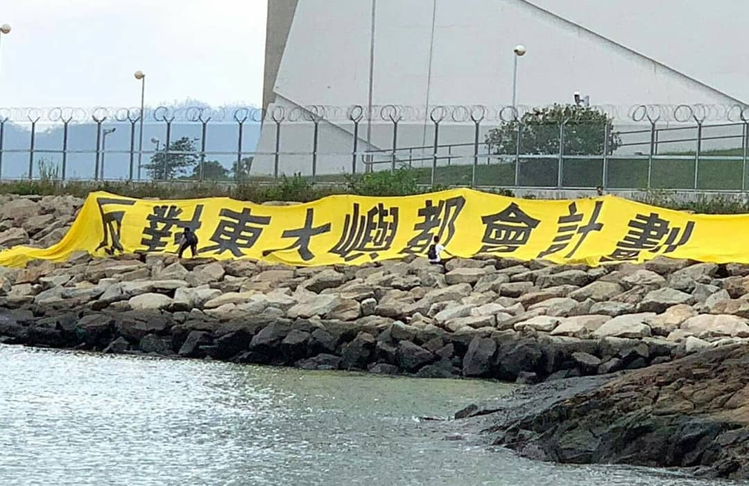 多名馬灣居民在青馬大橋海邊，掛上「反對東大嶼都會計劃」的巨型橫額。（網上圖片）