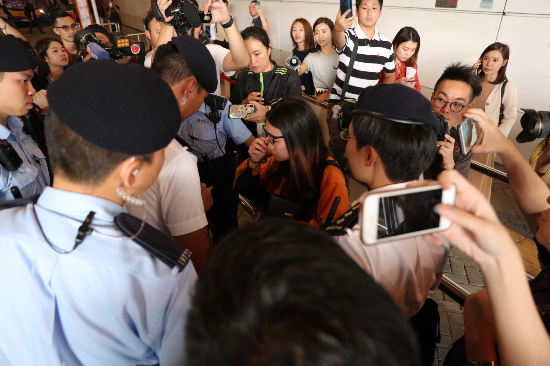 有內地女領隊（橙色衣者）被圍，在接受警方查問時，忍不住流淚。（陳百灝攝）