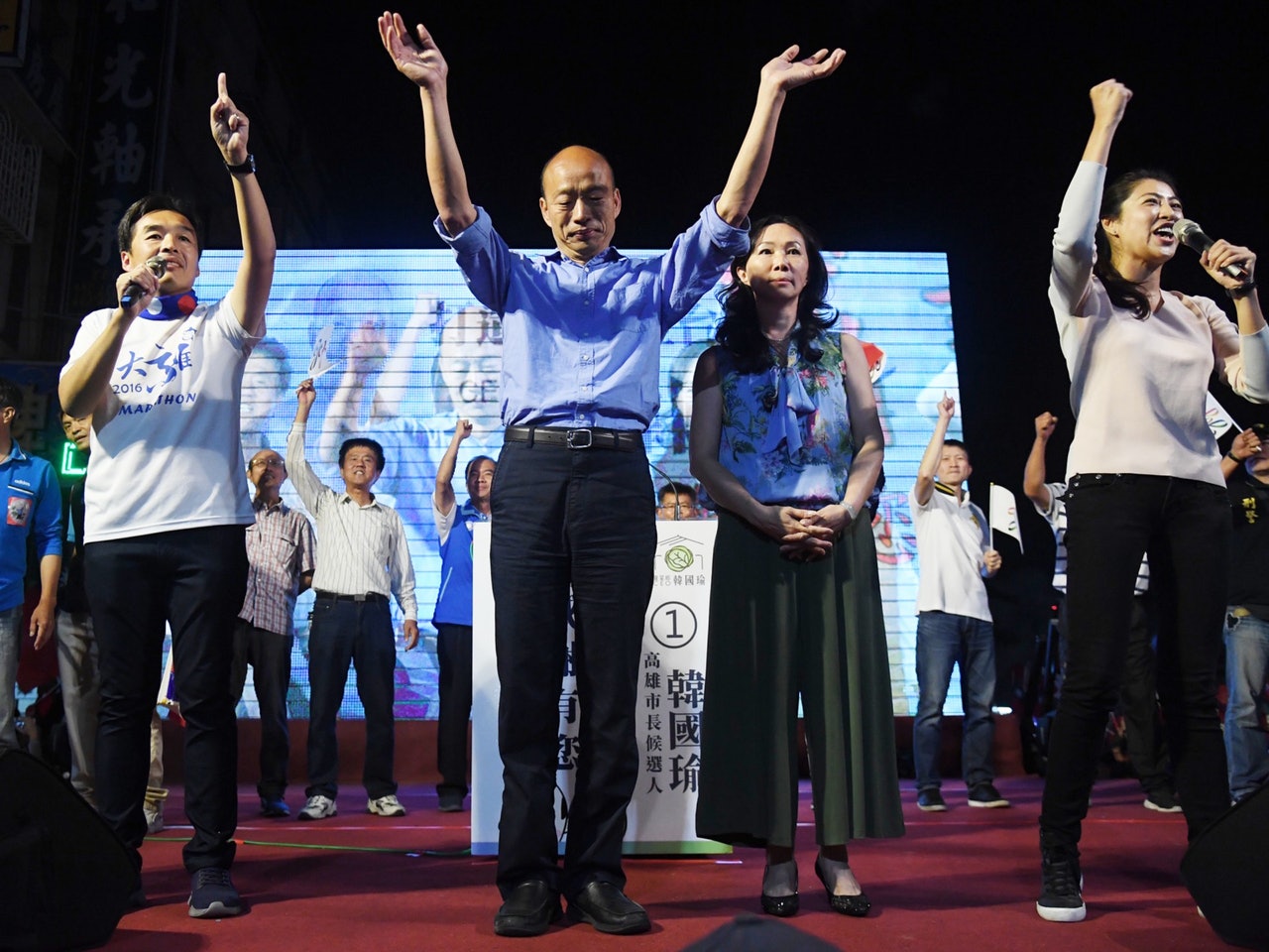 國民黨高雄市長候選人韓國瑜(前右3)自行宣布勝選,與妻子李佳芬(前右2)登台感謝選民支持,並發表勝選感言。(中央社) 國民黨高雄市長候選人韓國瑜(前右3)自行宣布勝選,與妻子李佳芬(前右2)登台感謝選民支持,並發表勝選感言。(中央社)