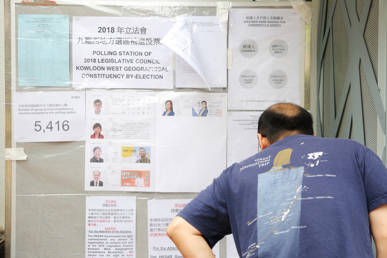 市民在票站外面閱讀告示。（歐嘉樂攝）