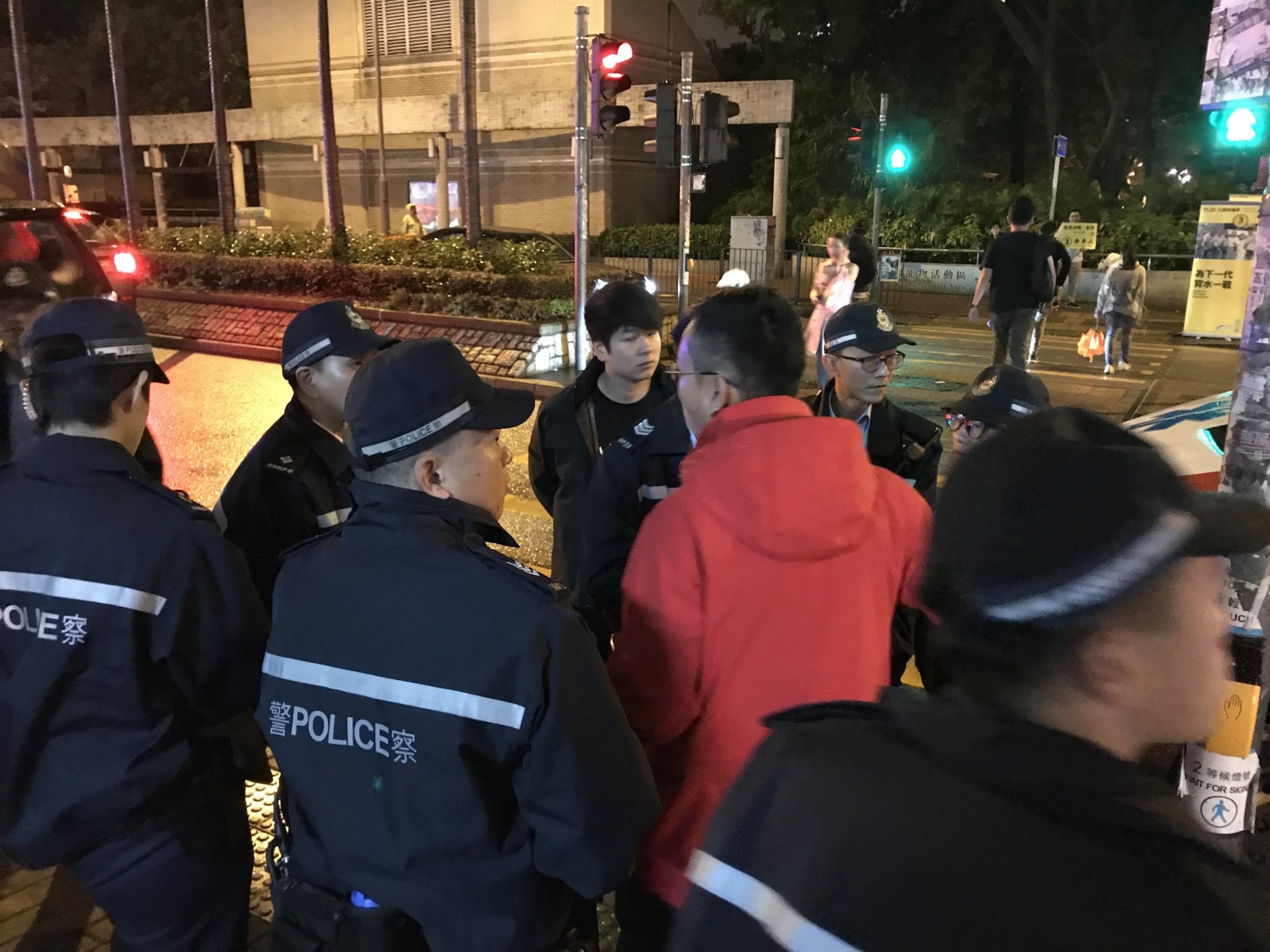 立法會議員陳恒鑌（紅色外套）在場向警員講述事件。（鄺曉斌攝）