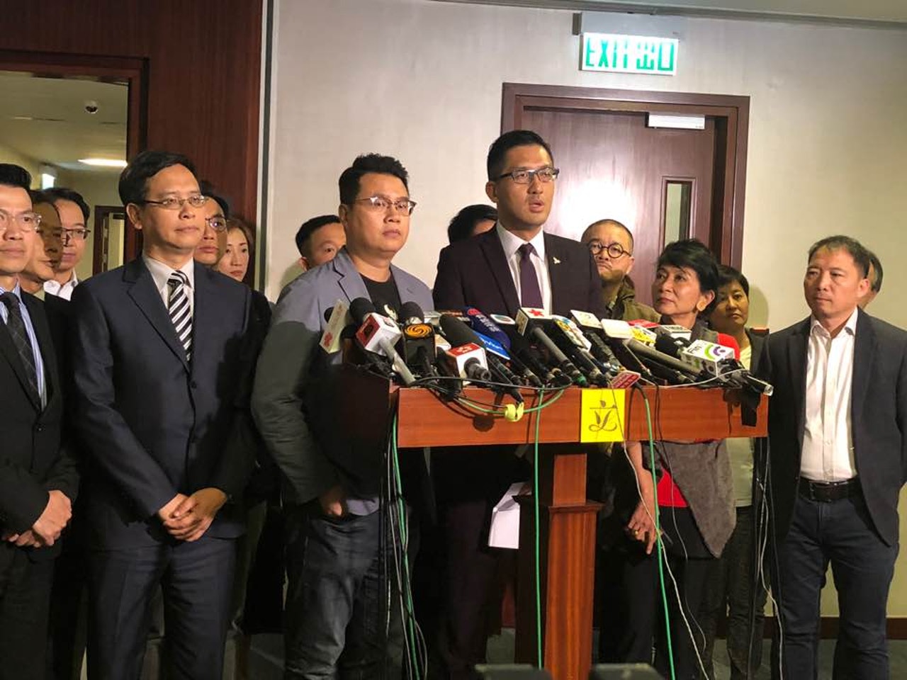 尹兆堅(前排左三)對控罪感到莫名其妙,指自己先被保安人員捉住雙手,其後才被梁君彥趕出議會聽,所謂襲擊罪實是倒果為因。(鄭榕笛攝) 尹兆堅(前排左三)對控罪感到莫名其妙,指自己先被保安人員捉住雙手,其後才被梁君彥趕出議會聽,所謂襲擊罪實是倒果為因。(鄭榕笛攝)