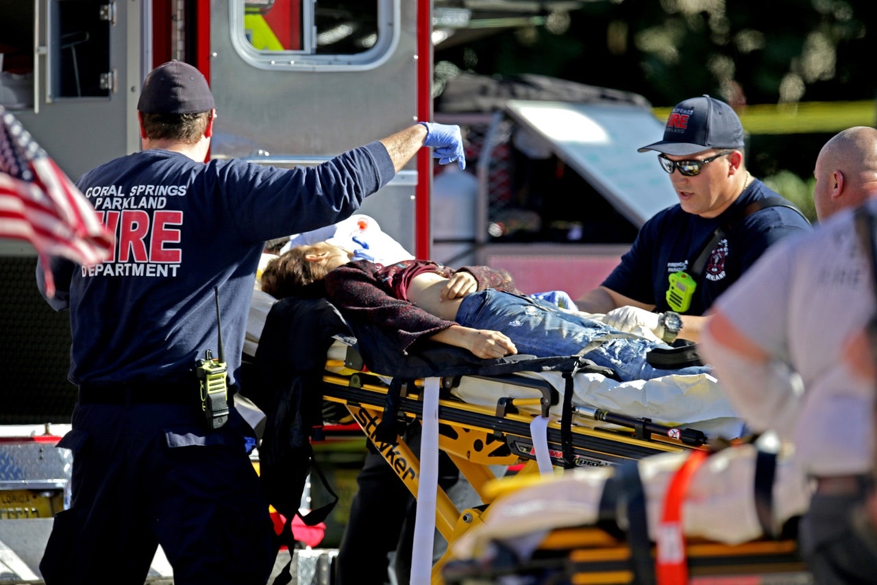 美國佛羅里達州帕克蘭（Parkland）瑪喬里斯通曼道格拉斯中學（Marjory Stoneman Douglas High School），2月14日發生槍擊案，17名師生不幸罹難。圖為救護人員把校園槍擊案傷者抬上救護車。（美聯社）