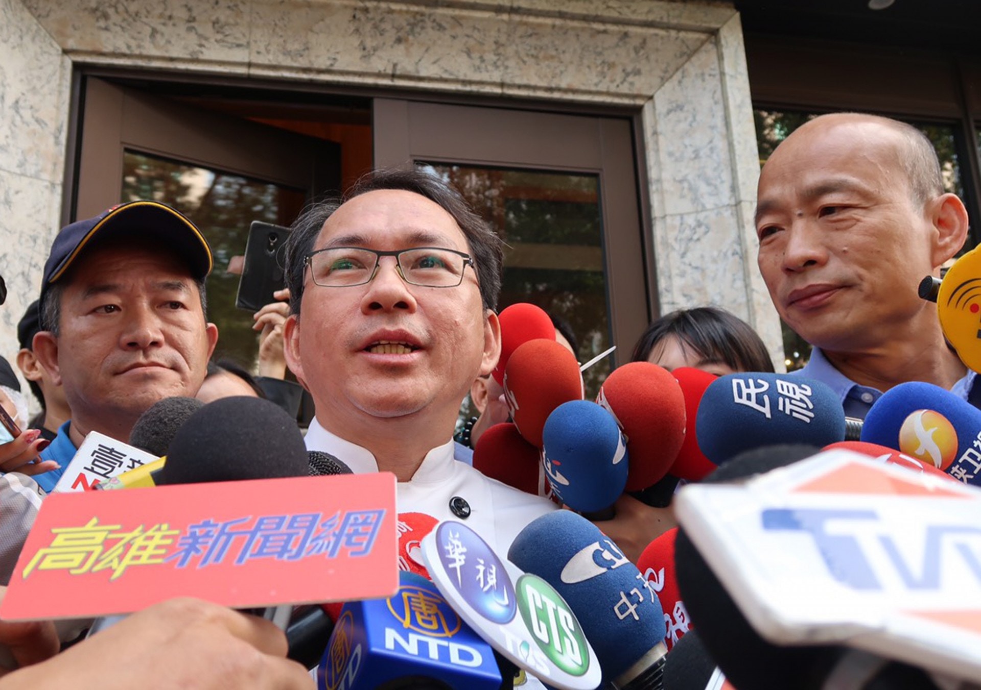 國民黨籍高雄市長當選人韓國瑜（右）11日陪同麵包師傅吳寶春（左2）對外說明，韓國瑜說，吳寶春只會做麵包不懂政治，這次事件讓吳寶春被搞得滿頭包，盼大家珍惜吳寶春。（中央社）