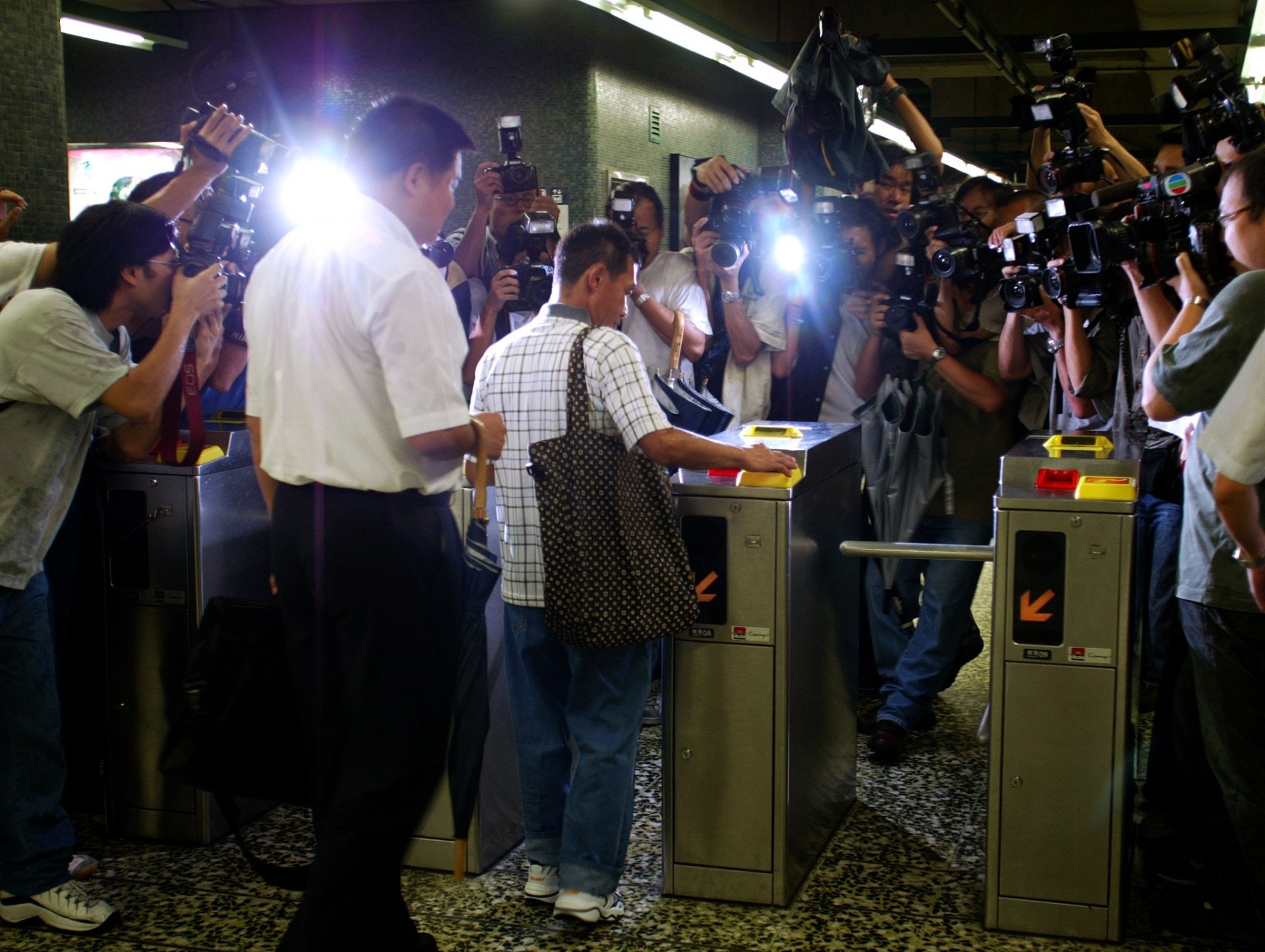 歐陽炳強2002年獲「有條件監管令」假釋，在懲教所人員的陪同下公開露面，首次乘搭地鐵，引來大批傳媒追訪。（資料圖片）