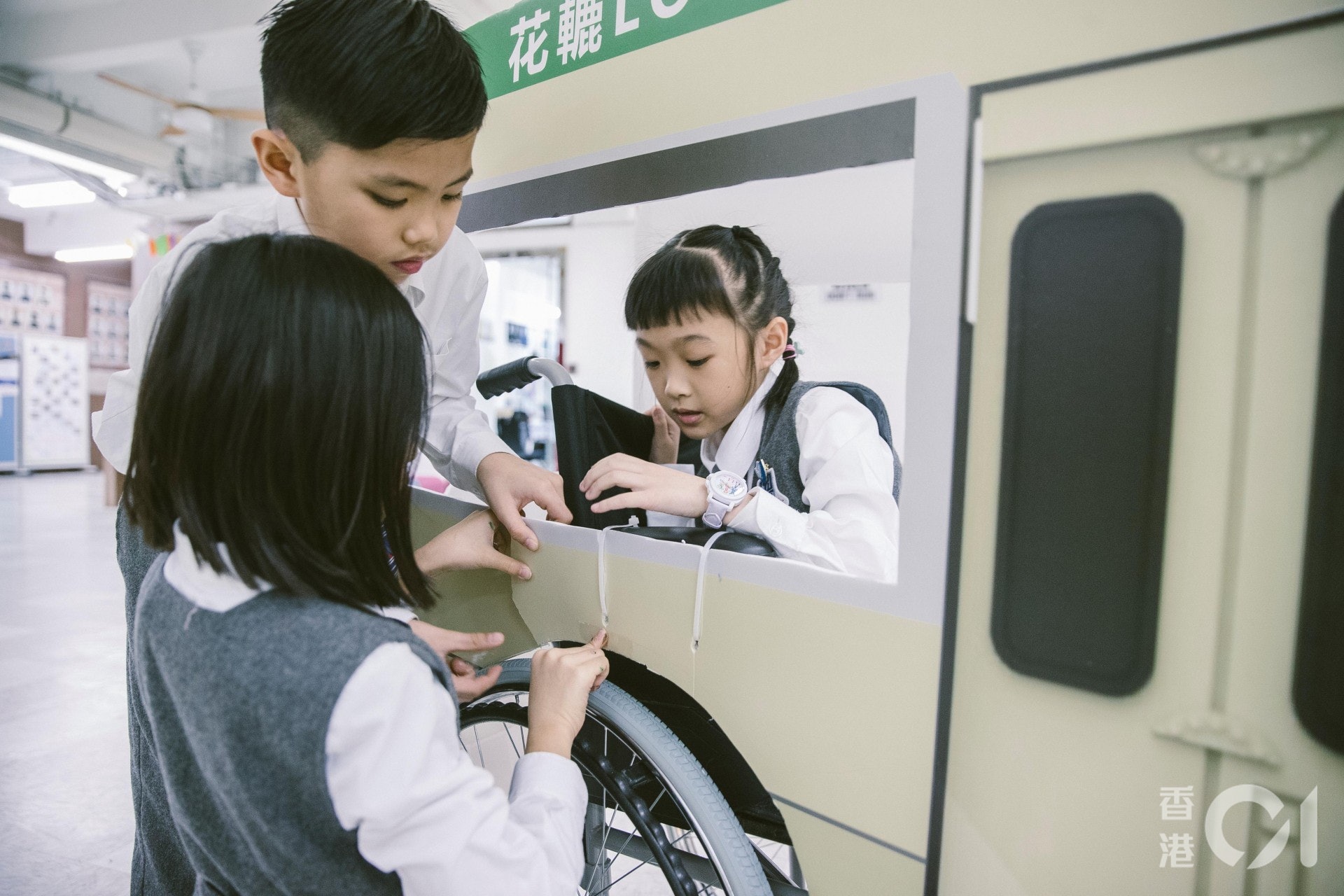 德萃小學的學生幫忙改造輪椅，將之變成一輛「十六座小巴」花車。(鄭子峰攝)