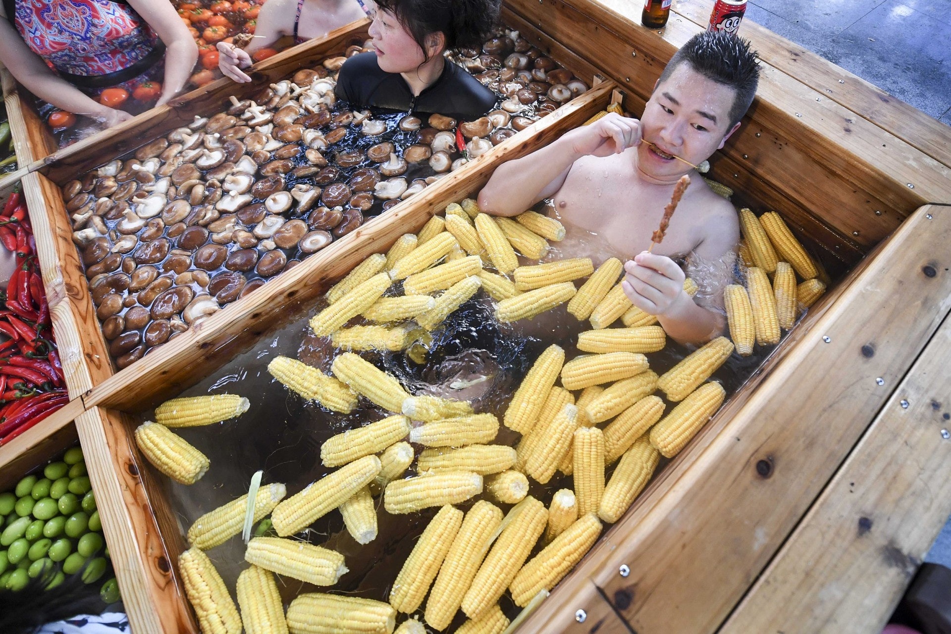 為迎接豬年,有杭州酒店推出九宮格火鍋溫泉,讓顧客泡浸各種火鍋配料時同時享用巨型豬肉串。(視覺中國) 為迎接豬年,有杭州酒店推出九宮格火鍋溫泉,讓顧客泡浸各種火鍋配料時同時享用巨型豬肉串。(視覺中國)