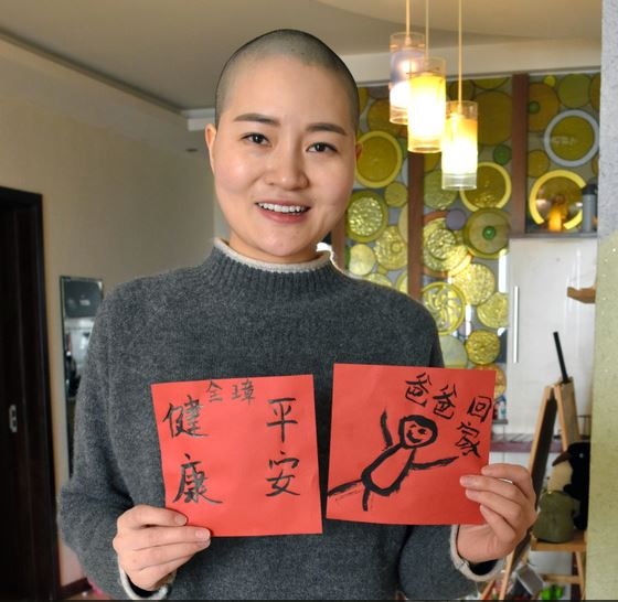 李文足展示兒子寫的「春聯」。（朝日新聞）