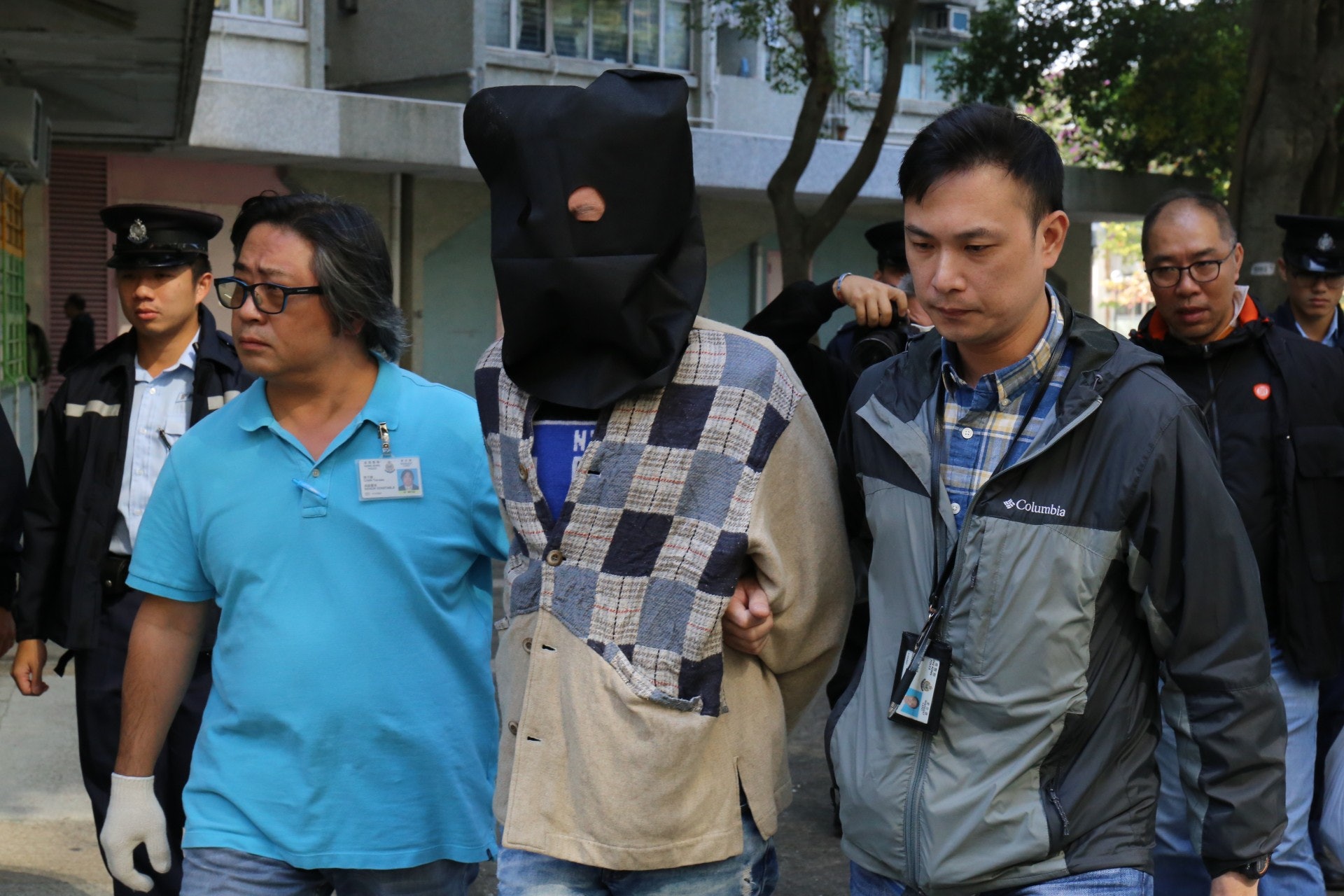 被告李偉文(黑布蒙頭)否認謀殺男子丁潤光。(資料圖片) 被告李偉文(黑布蒙頭)否認謀殺男子丁潤光。(資料圖片)