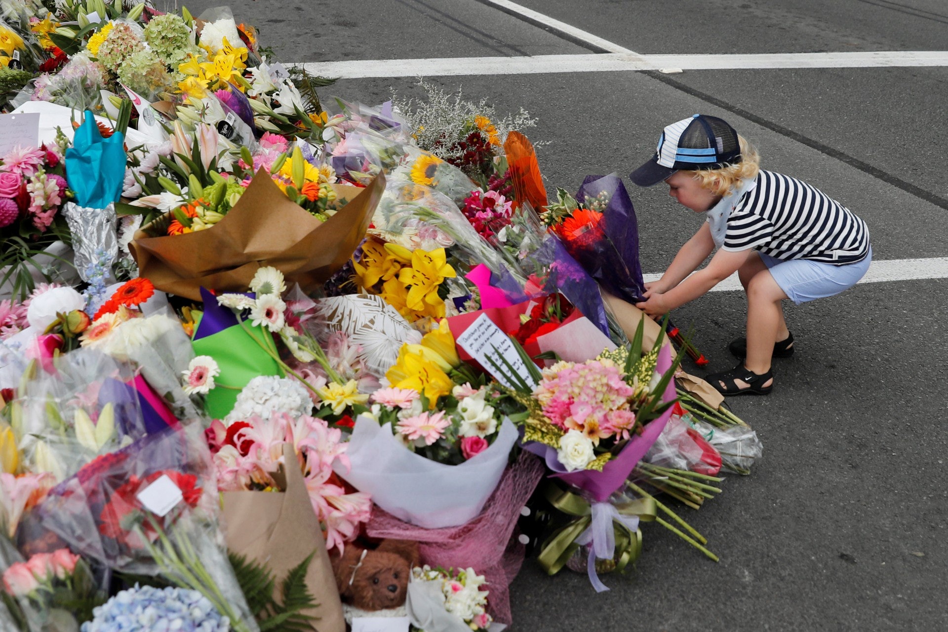 新西蘭基督城恐襲：一名男孩3月15日在其中一間遇襲的清真寺附近獻花。新西蘭總檢察長柏克（David Parker）在奧克蘭出席悼念活動時警告全球正面對極端主義冒起。（路透社）