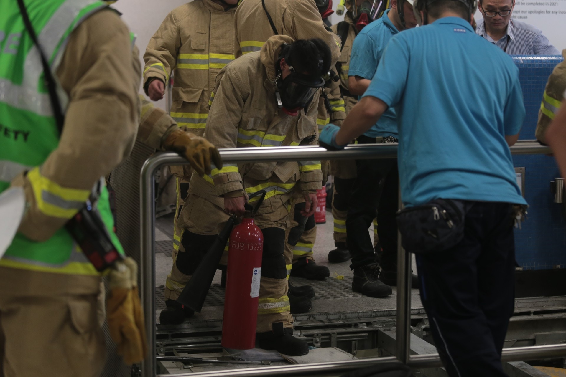 消防員用滅火筒噴向冒煙位置。（余睿菁攝）