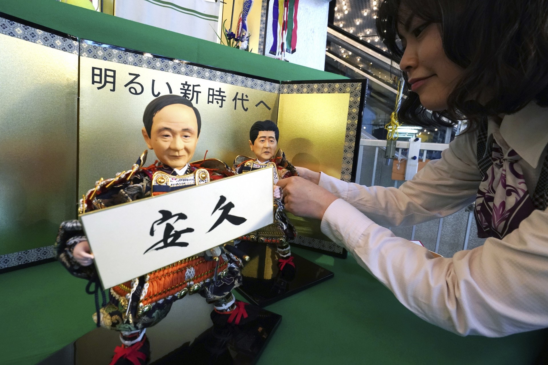 日本新年號：有工藝師精心製作以首相安倍晉三和內閣官房長官菅義偉為主題的五月人偶，並加上坊間預測新年號的牌子。（美聯社）