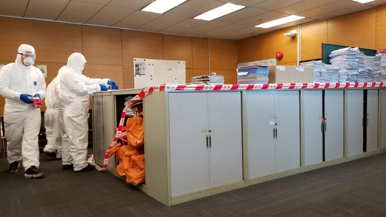 衞生署人員身穿全套保護衣，今午到國泰貨運站5樓消毒，並圍封中招員工的工作範圍。（國泰工會提供）