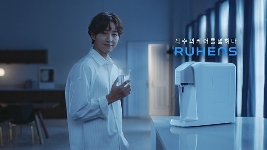 宋仲基最近代言在淨水器廣告中，以鬆身恤衫的斯文形象示人。（Naver）