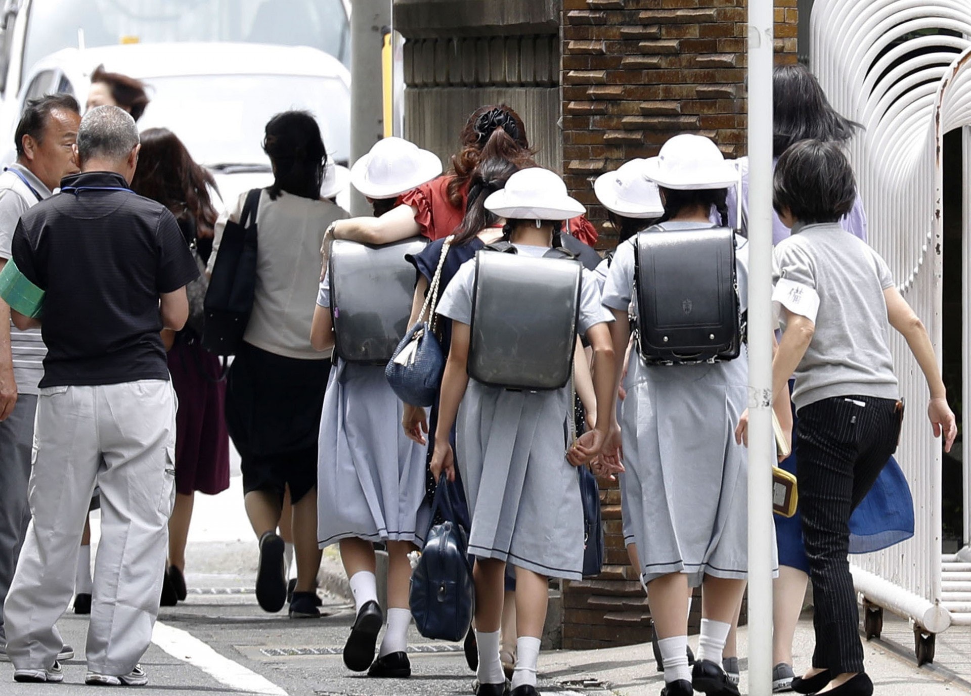 日本神奈川縣川崎市周二(28日)發生持刀襲擊事件後,多名學生受傷的明愛小學隨即宣布停課。學生在家長陪同下離開學校。(美聯社) 日本神奈川縣川崎市周二(28日)發生持刀襲擊事件後,多名學生受傷的明愛小學隨即宣布停課。學生在家長陪同下離開學校。(美聯社)