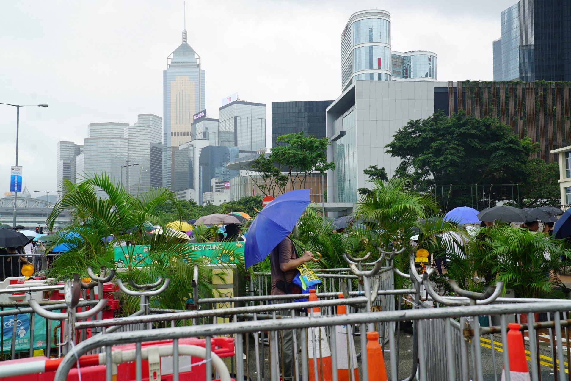 下大雨，胡少冕一直撐傘站在解放軍大樓外，身影單薄但倔強。