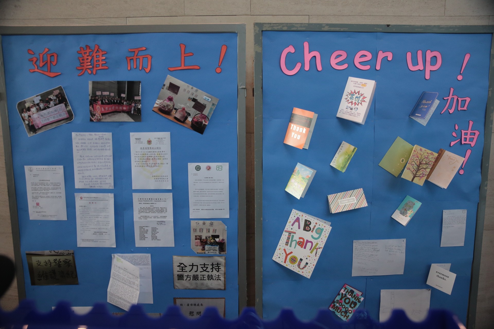 該個貼有「迎難而上！」、「Cheer Up!」、「加油」字眼的展覽板設在警總3樓大堂內。面對近日「警民關係」的緊張，有部分團體向警隊發信以示支持，該展覽板上展示了相關信件、心意卡、相片等。（梁銘康攝）