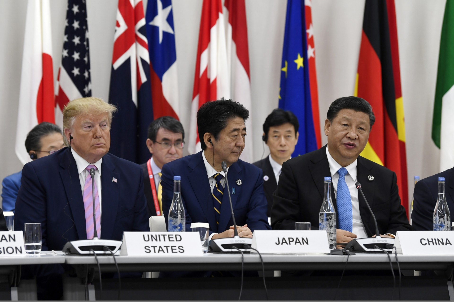 G20峰會:6月28日早上會議正式開始前,特朗普、安倍晉三及習近平並排而坐。這個座位安排引起外界好奇。(美聯社) G20峰會:6月28日早上會議正式開始前,特朗普、安倍晉三及習近平並排而坐。這個座位安排引起外界好奇。(美聯社)