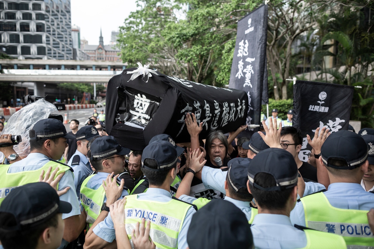 ［07:19］升旗禮之前，社民連欲前往金紫荊廣場示威，梁國雄準備棺材作為示威道具，遭大批警察阻止。（羅國輝攝）