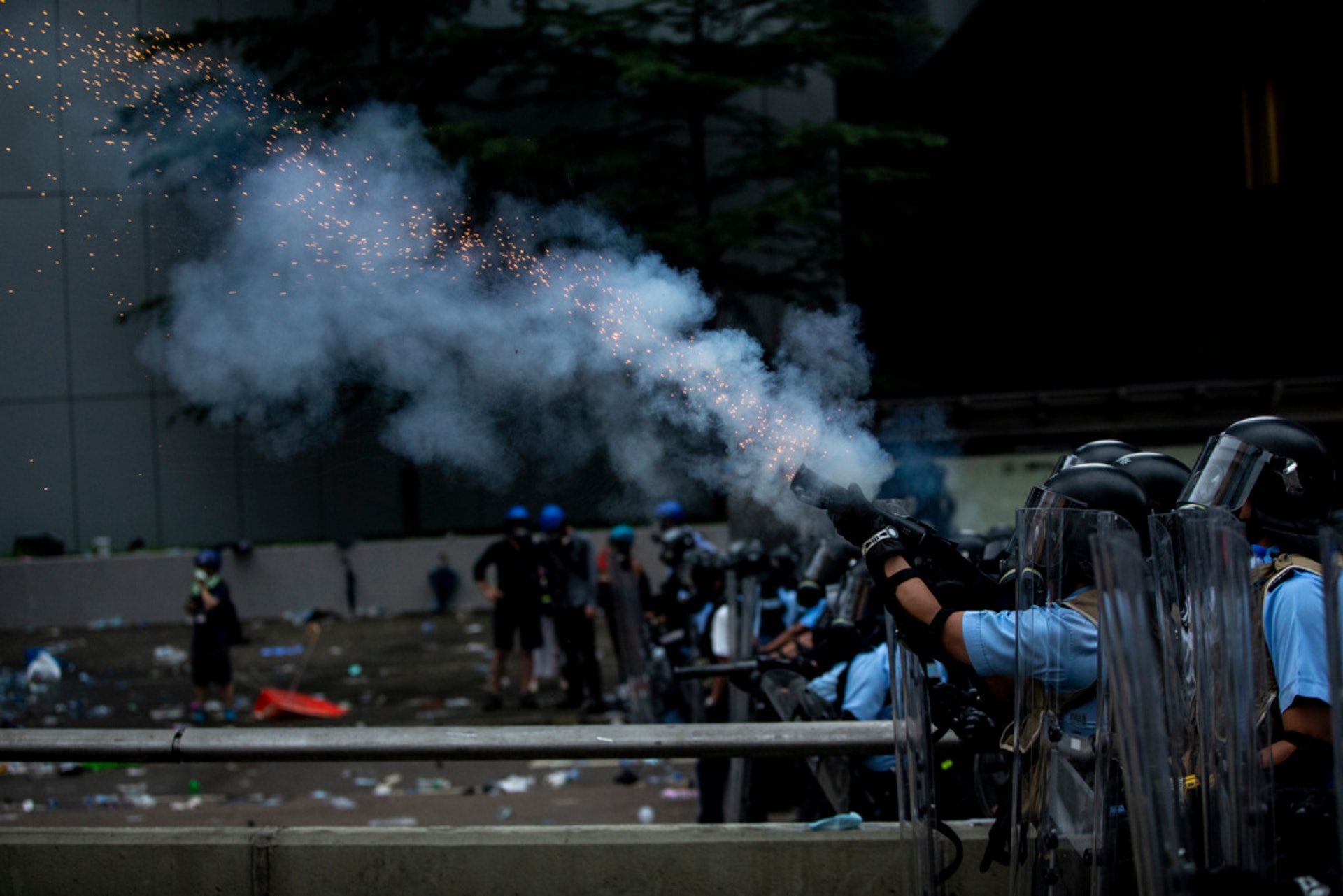 示威者以堵路、衝擊作為示威手段，政府調動警察對付示威者，亦令警察捲入政治漩渦。圖為警方在6月12日衝突中向示威者施放催淚彈。（羅君豪攝）