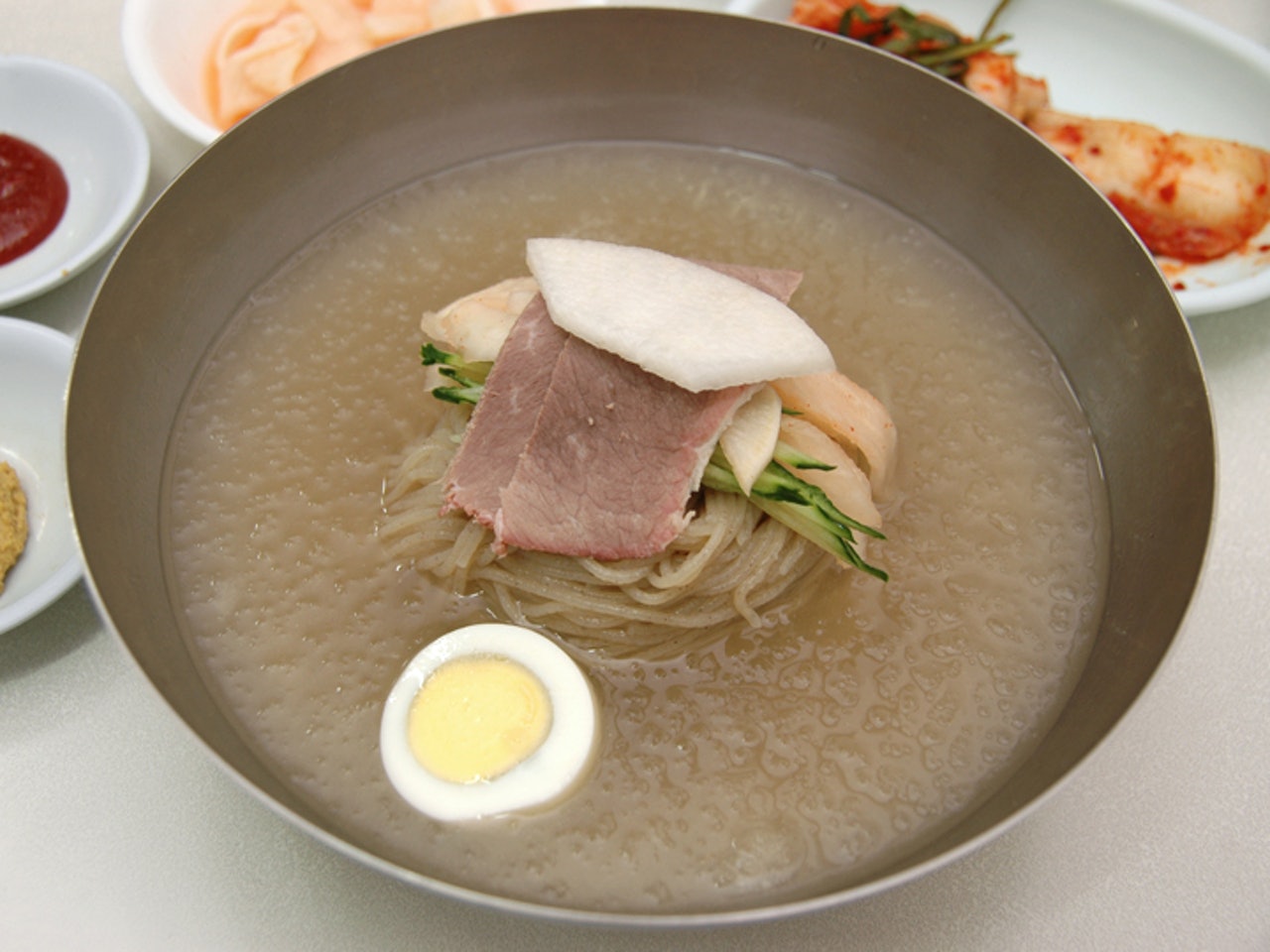 根據製作冷麵的食材。平壤冷麵=水冷麵,鹹興冷麵=拌冷麵是比較傳統的認識,不過很多店裏都同時出售這兩種冷麵。既然遠道而來到了韓國,不妨去吃一吃比較一下有什麽區別吧。(韓巢網提供) 根據製作冷麵的食材。平壤冷麵=水冷麵,鹹興冷麵=拌冷麵是比較傳統的認識,不過很多店裏都同時出售這兩種冷麵。既然遠道而來到了韓國,不妨去吃一吃比較一下有什麽區別吧。(韓巢網提供)