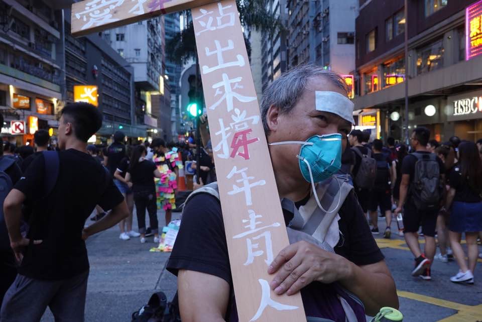 年逾五旬、有「翻版林兆波」之稱的江先生繼九龍區遊行，再次高舉約三米高的十字架。(李穎霖攝)