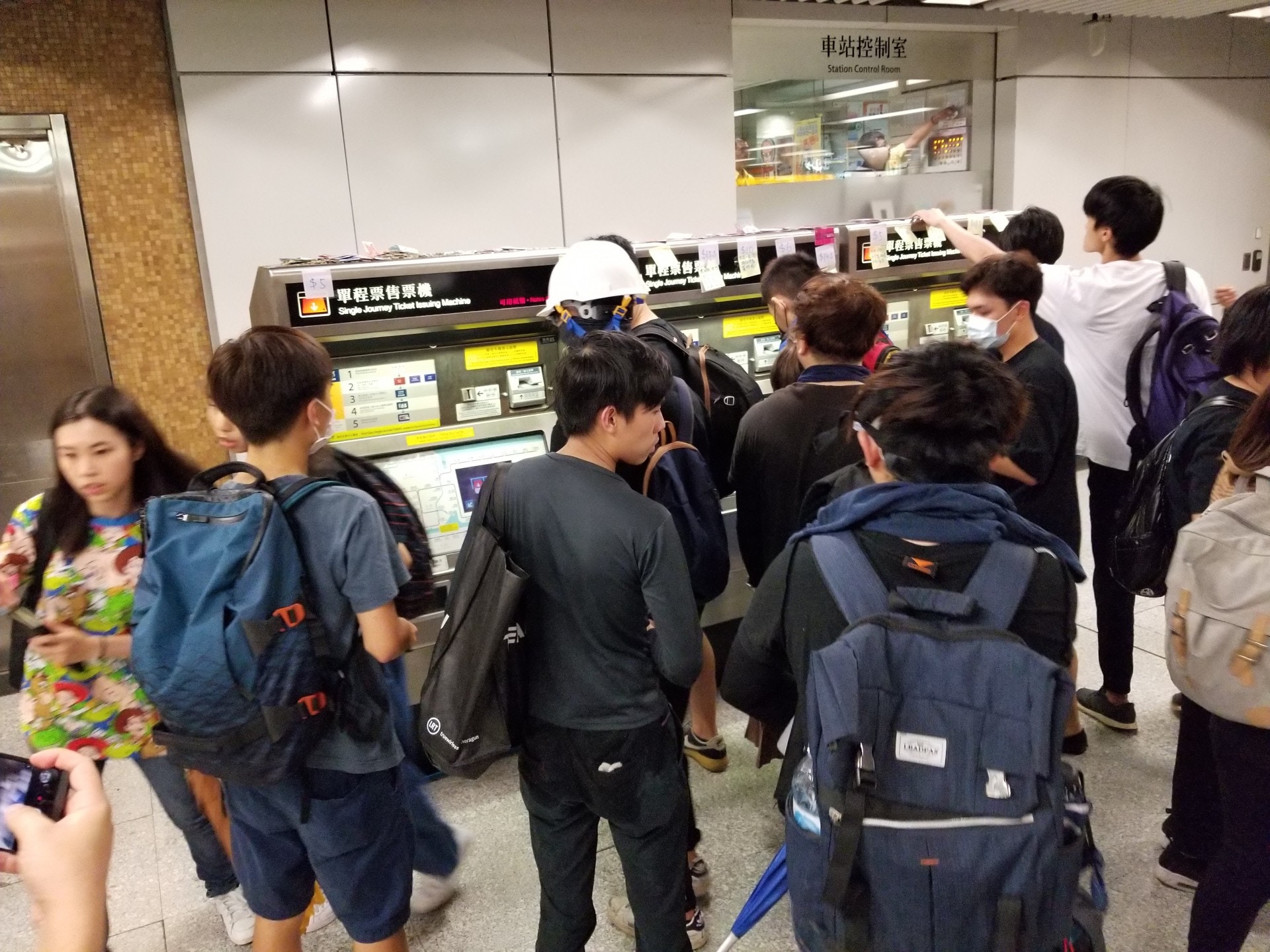 港鐵上環站有示威者購買衣服供更換，又用零錢放於購票機上購買單程票。（王譯揚攝）