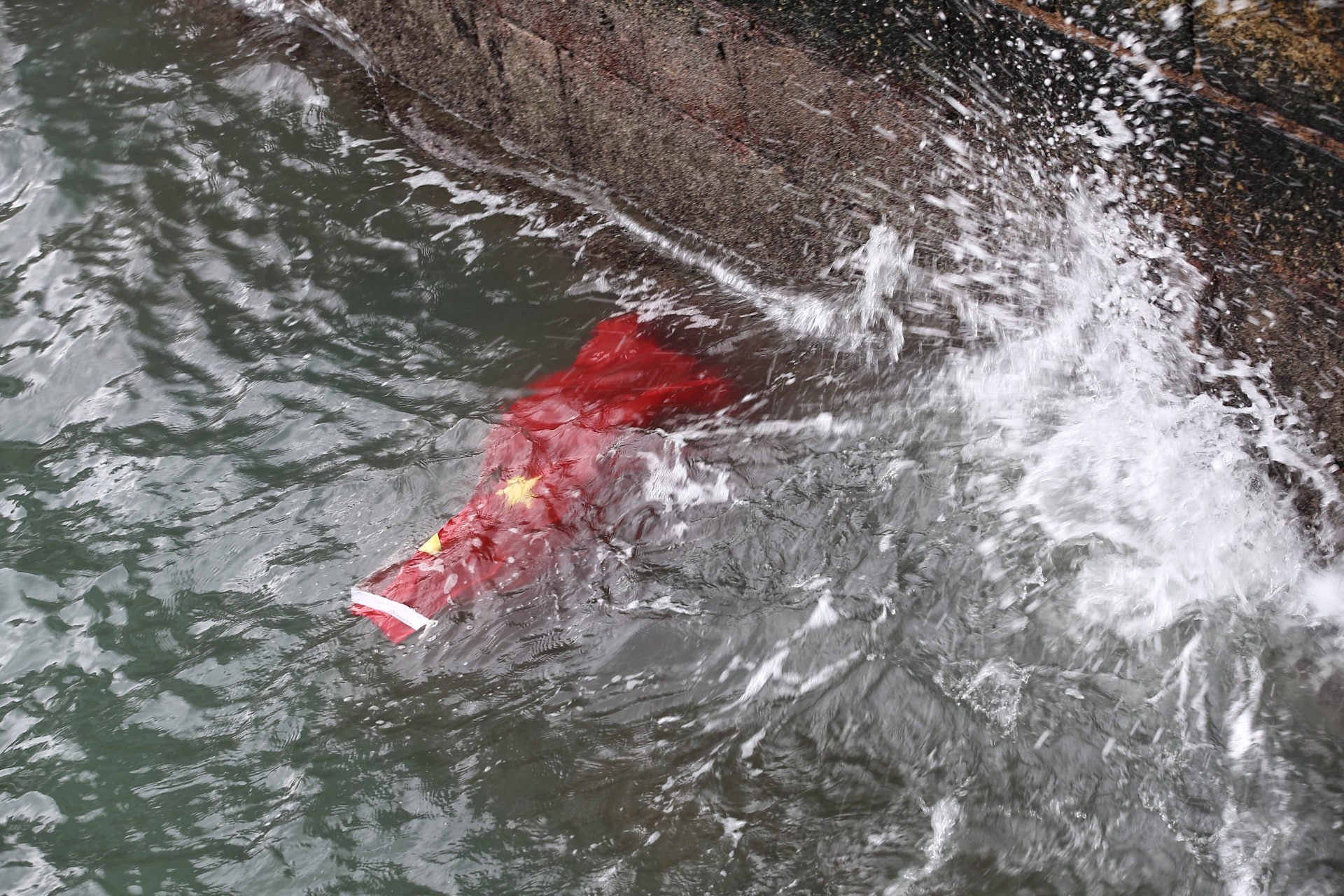 下午5時40分,示威者拆走海港城五支旗桿上的國旗,國旗被掉入海中,示威者其後立刻跑走,說去「鳩嗚」。(羅君豪攝攝)