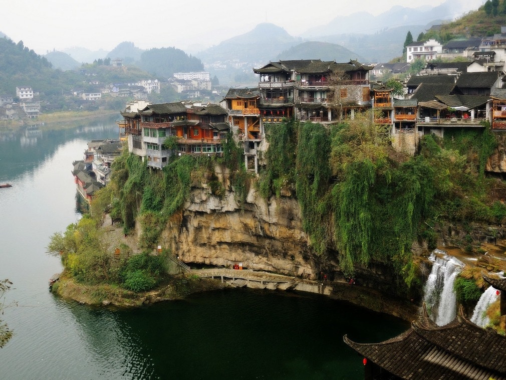 芙蓉鎮本名王村，是擁有兩千多年歷史的古鎮，因宏偉瀑布穿梭其中，又稱「掛在瀑布上的千年古鎮」。（視覺中國）